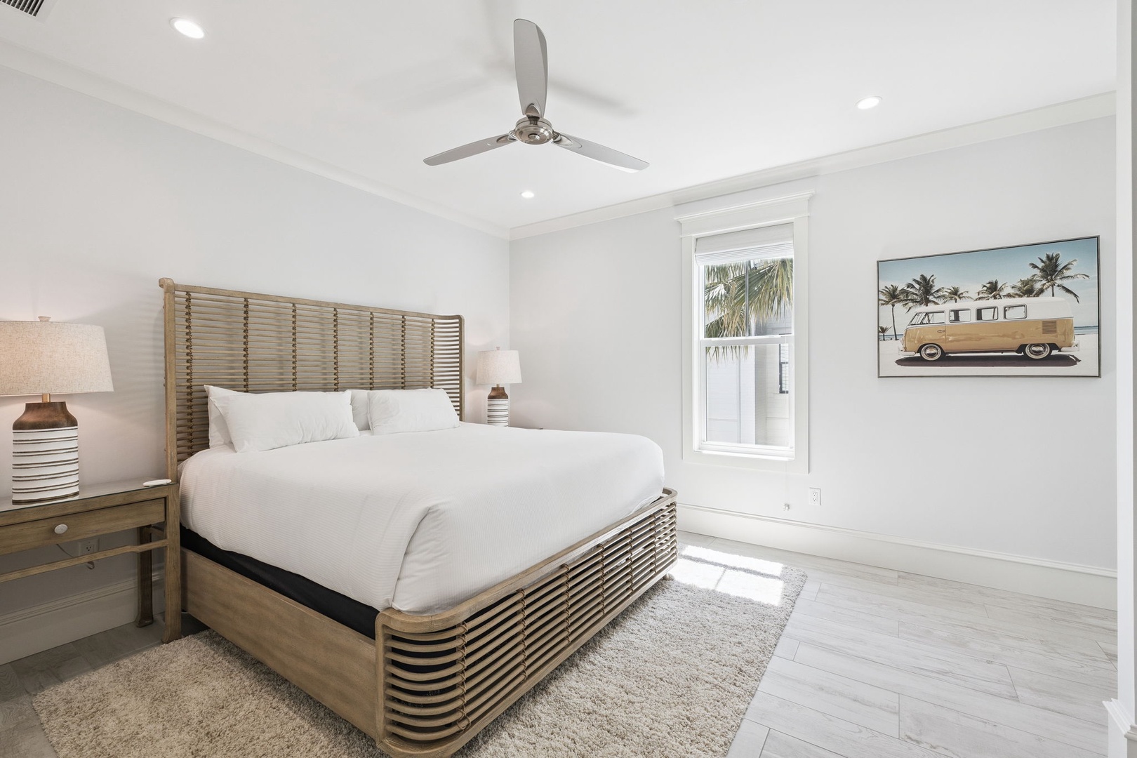 Sink into crisp white linens and wake to tropical breezes in your serene bedroom sanctuary with modern coastal charm.