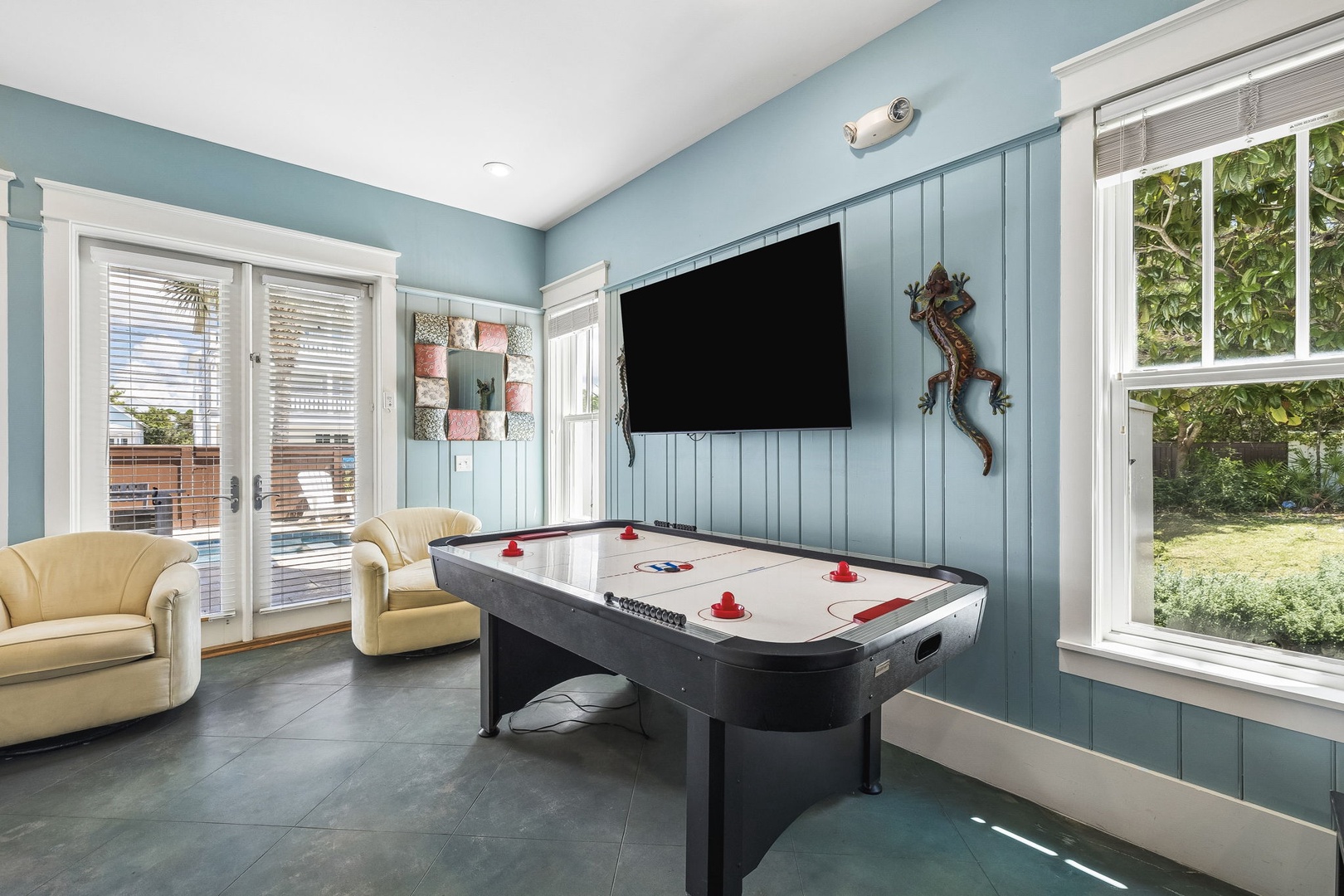 Challenge your travel companions to a lively air hockey match in this bright, inviting game room. Relax on comfortable seating after your game and enjoy views of the lush backyard through expansive windows.