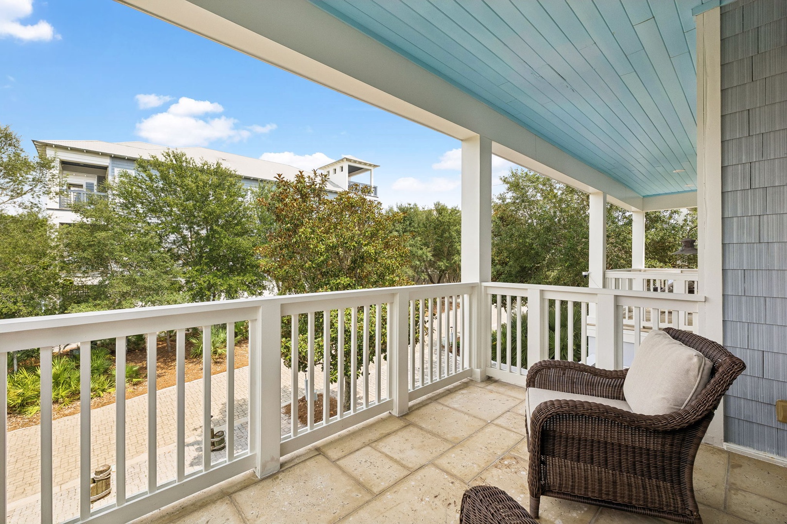 Settle into your private covered balcony with a comfy wicker chair and let the leafy treetop views soothe your senses—a perfect quiet spot for morning coffee or watching the clouds drift by.