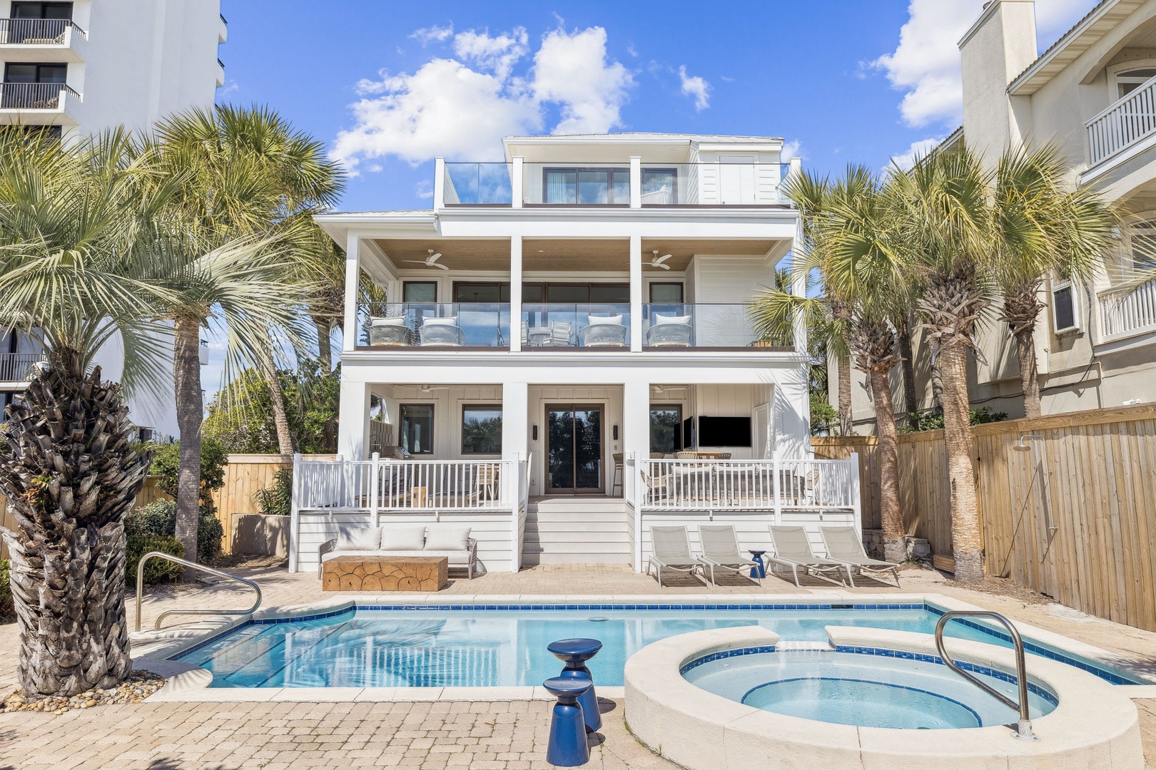 Modern beachside villa featuring private pool and hot tub surrounded by swaying palms—your perfect coastal retreat.