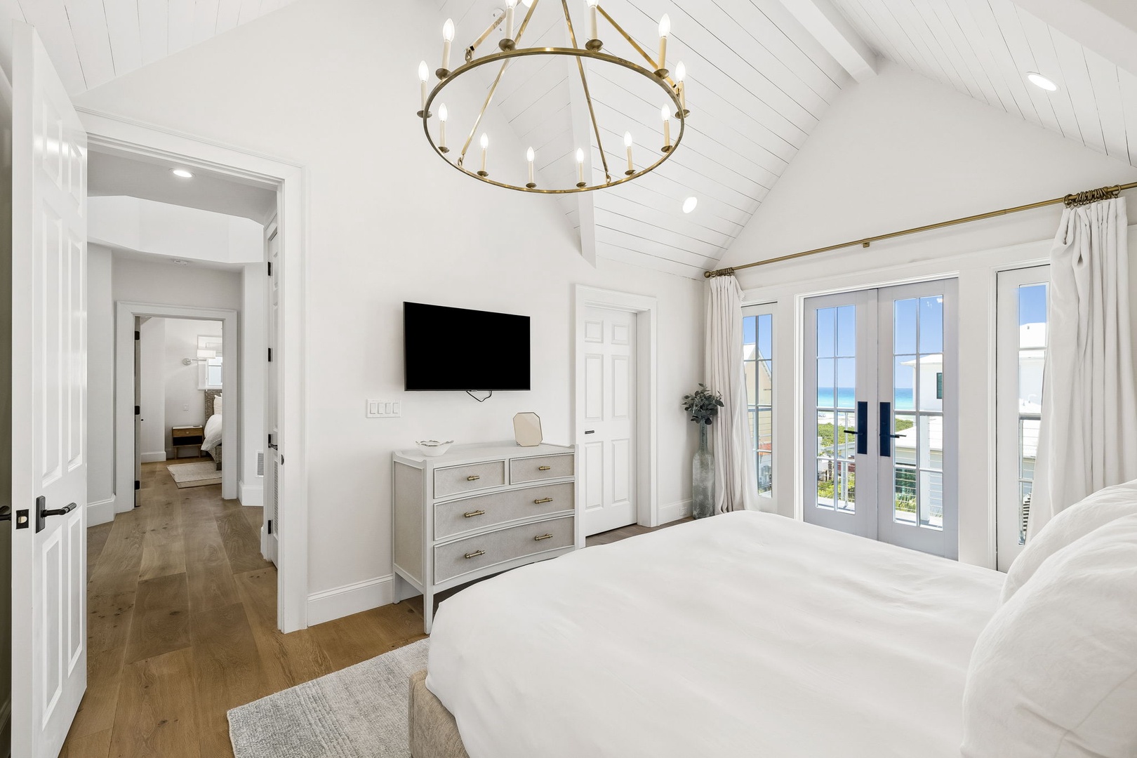 Wake up to ocean breezes and coastal views from your serene master suite, where vaulted ceilings and French doors frame the perfect morning light.
