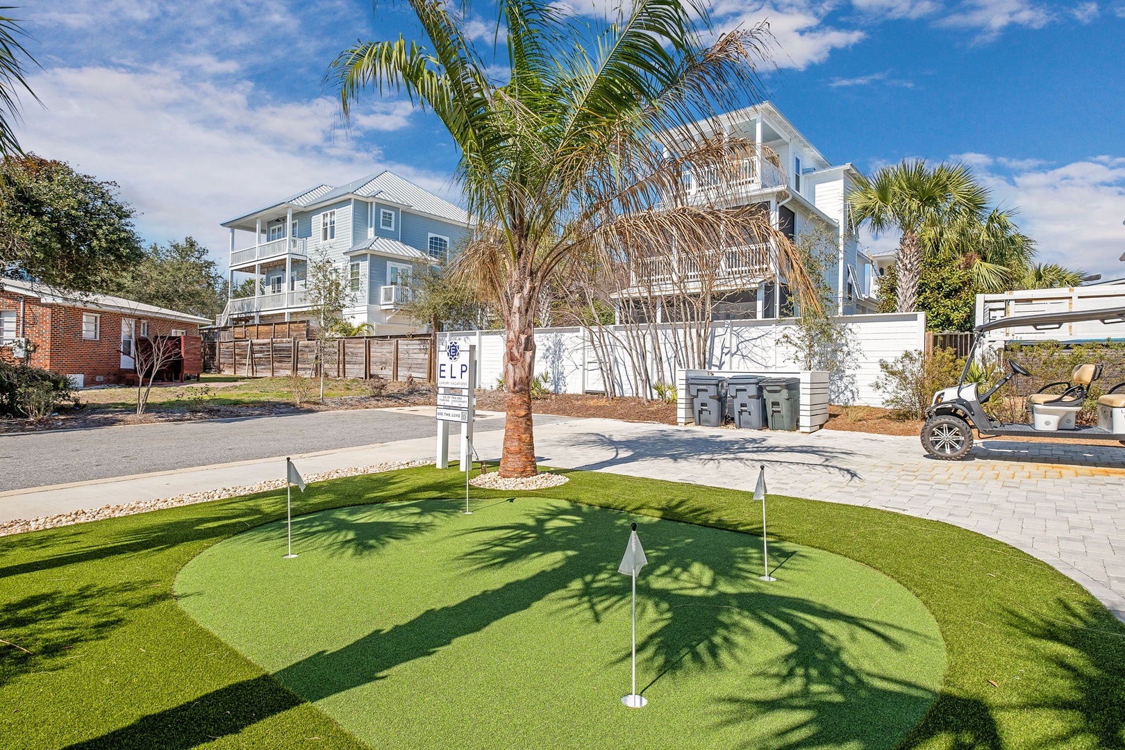 Private putting green with tropical palms creates the perfect backyard escape for golf enthusiasts.