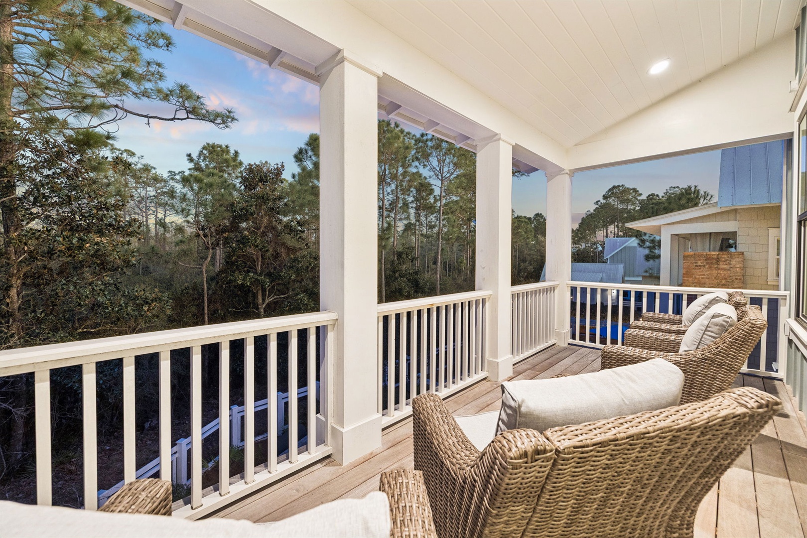 Unwind on your private covered balcony, where cozy wicker seating meets stunning treetop views for perfect morning coffee moments.