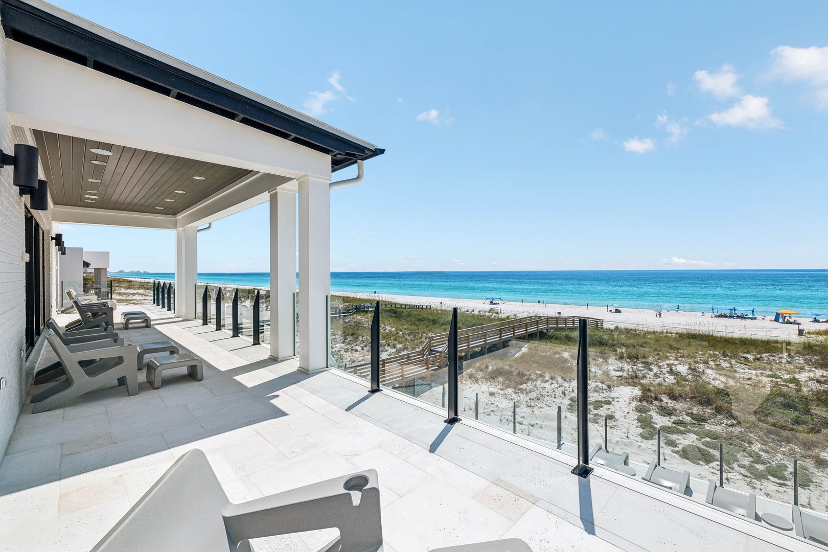 A covered terrace overlooks pristine white sands and turquoise waters, perfect for basking in sun-soaked mornings or watching the waves with your favorite drink.