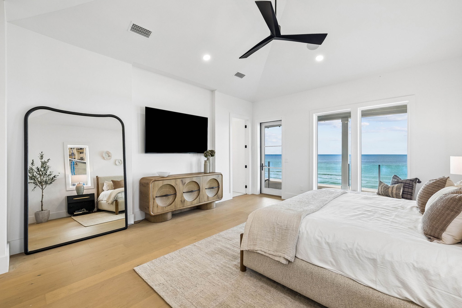 Wake up to breathtaking ocean views from your serene bedroom, where natural light pours through expansive windows and gentle waves provide your daily soundtrack. Modern coastal elegance meets comfort in your private retreat.