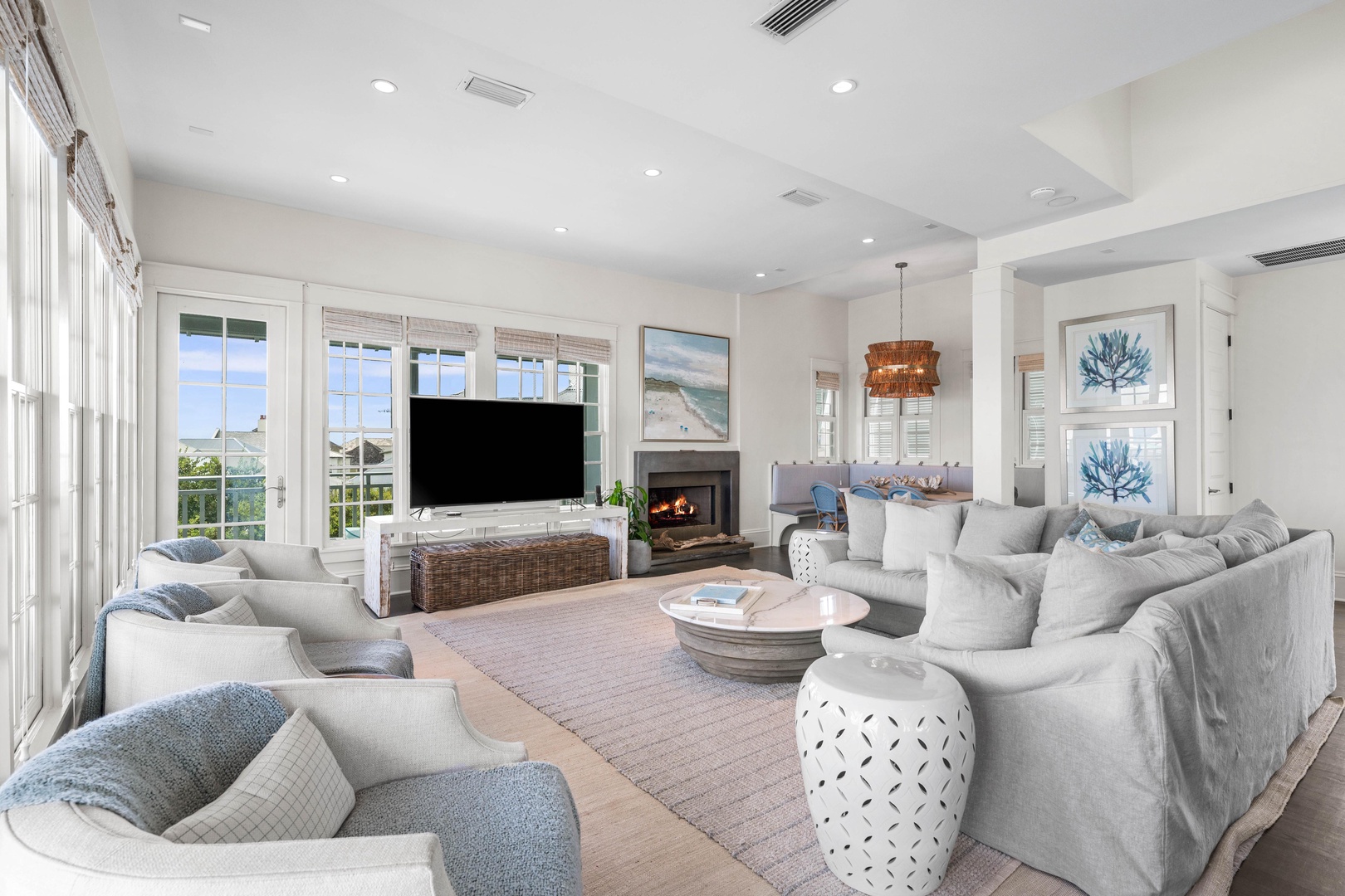 Sink into plush sectional seating by your fireplace, where coastal artwork and abundant natural light create the perfect atmosphere for relaxation.