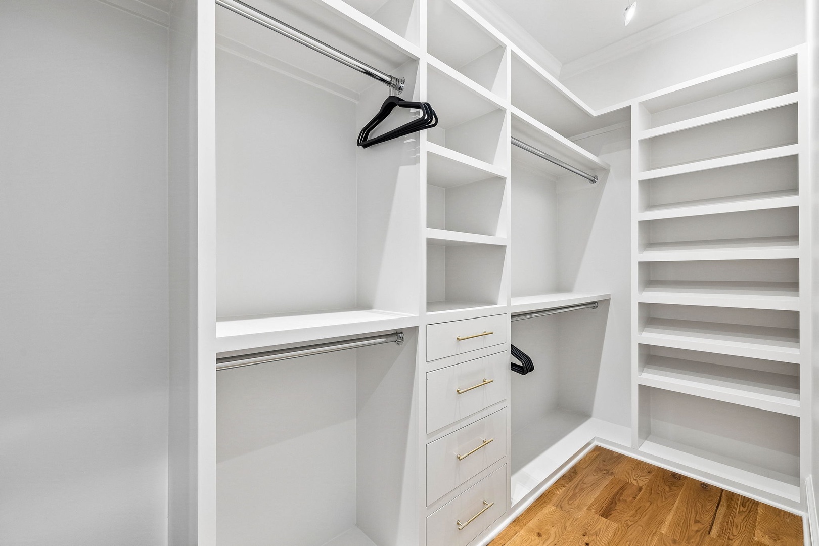 Your walk-in closet offers plenty of hanging space, built-in drawers, and open shelving to keep your belongings organized and easily accessible throughout your stay.