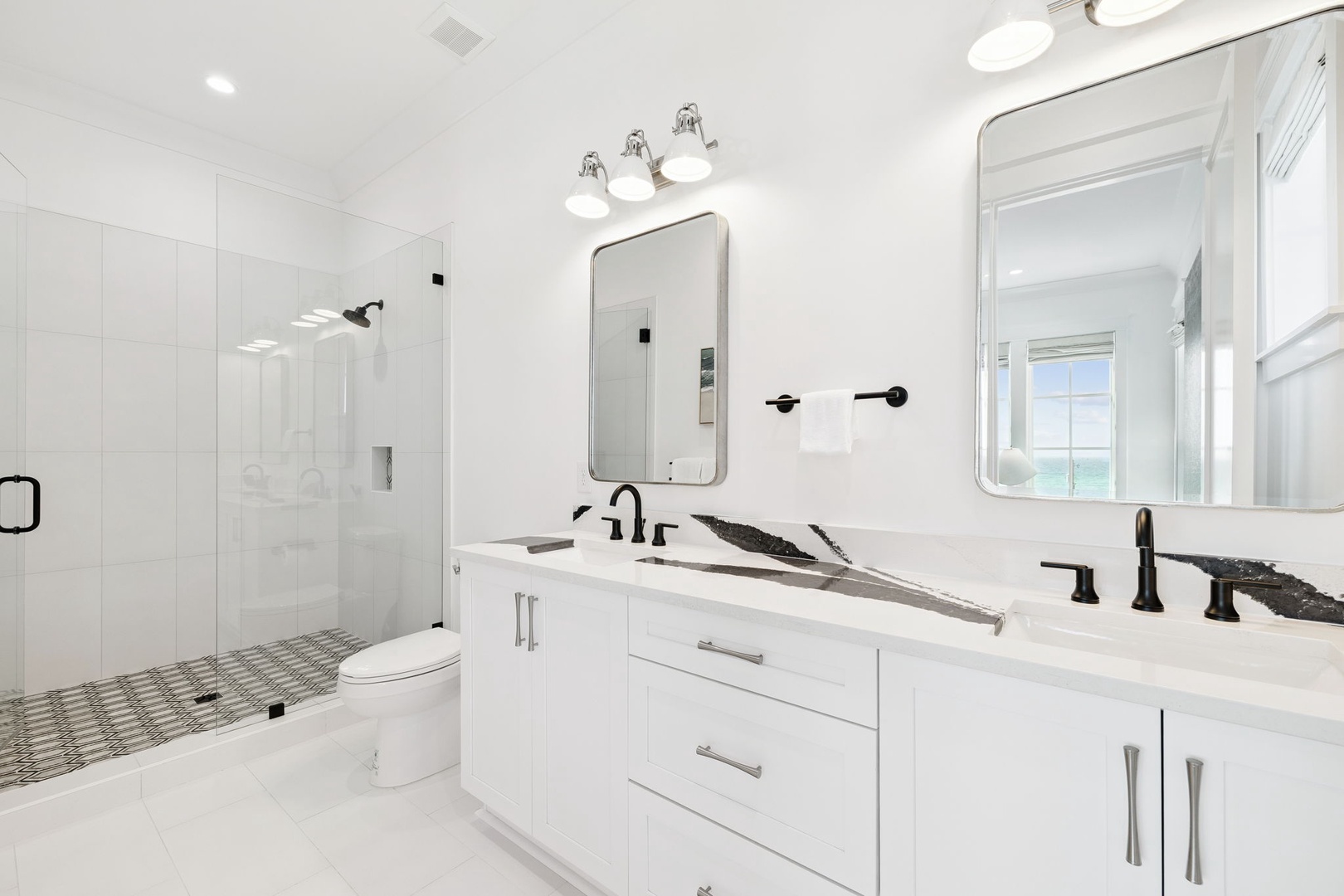 Step into your spa-like bathroom sanctuary with dual vanities, rainfall shower, and elegant white marble finishes.