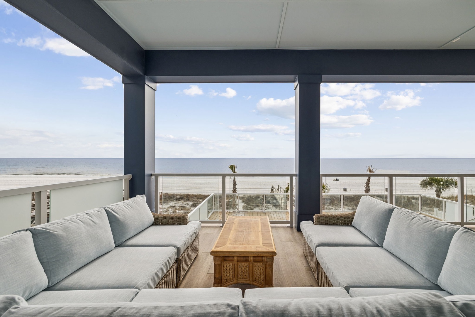 Sink into plush cushions while ocean waves dance before your eyes on this stunning covered terrace with panoramic sea views.