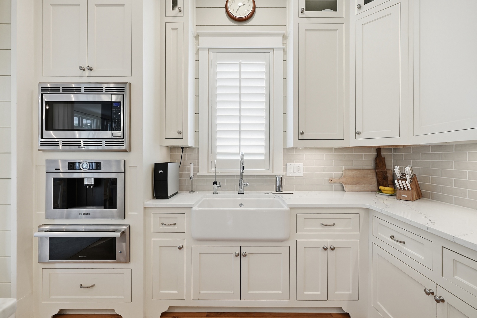 Picture yourself preparing meals in this bright, well-equipped kitchen with gleaming countertops, modern appliances, and charming farmhouse details. Every cooking need is met with style and ease.
