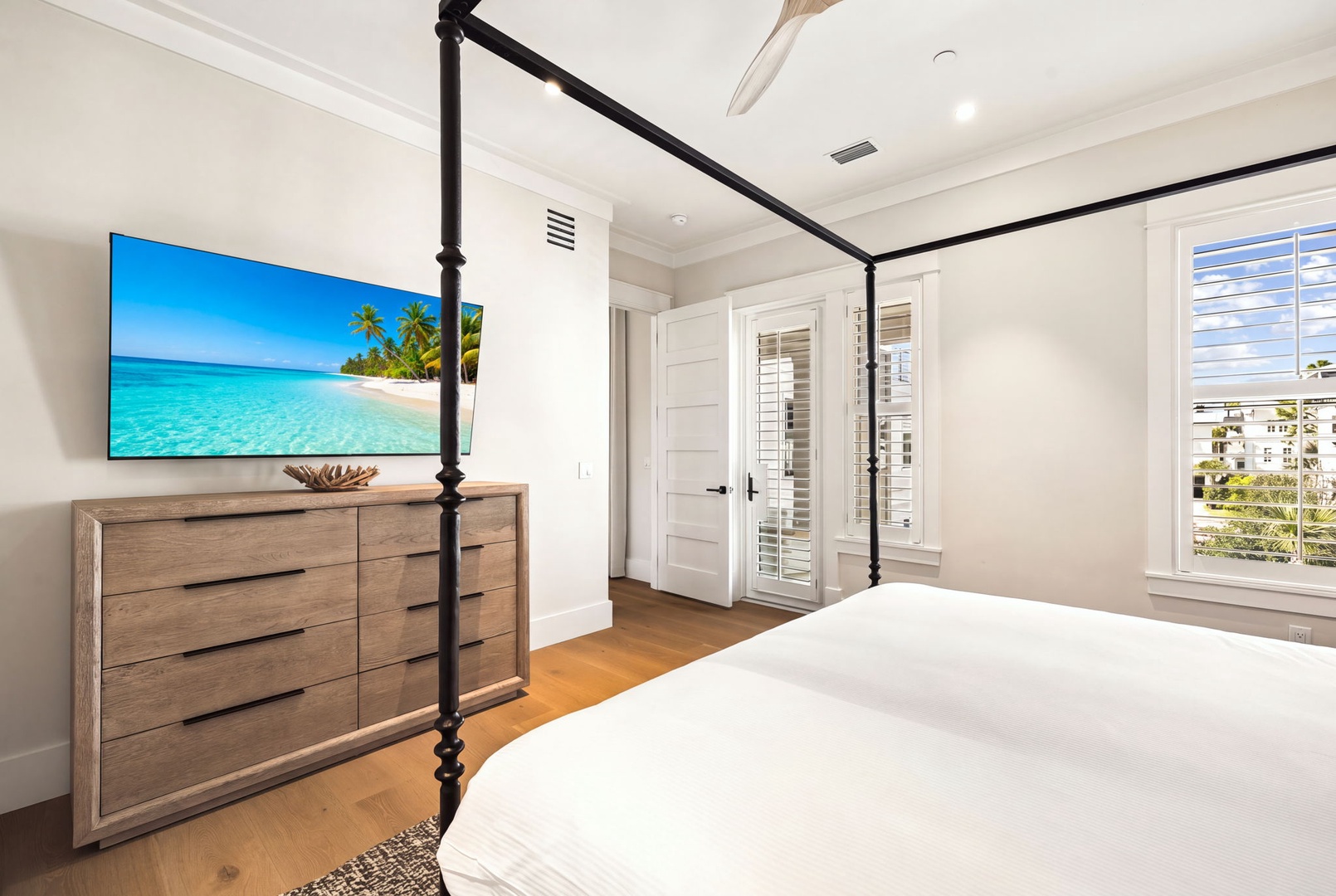 Relax in your elegant bedroom with a stunning four-poster bed, hardwood floors, and a balcony access. Enjoy views of the neighborhood from your windows and unwind with all the comforts of home.