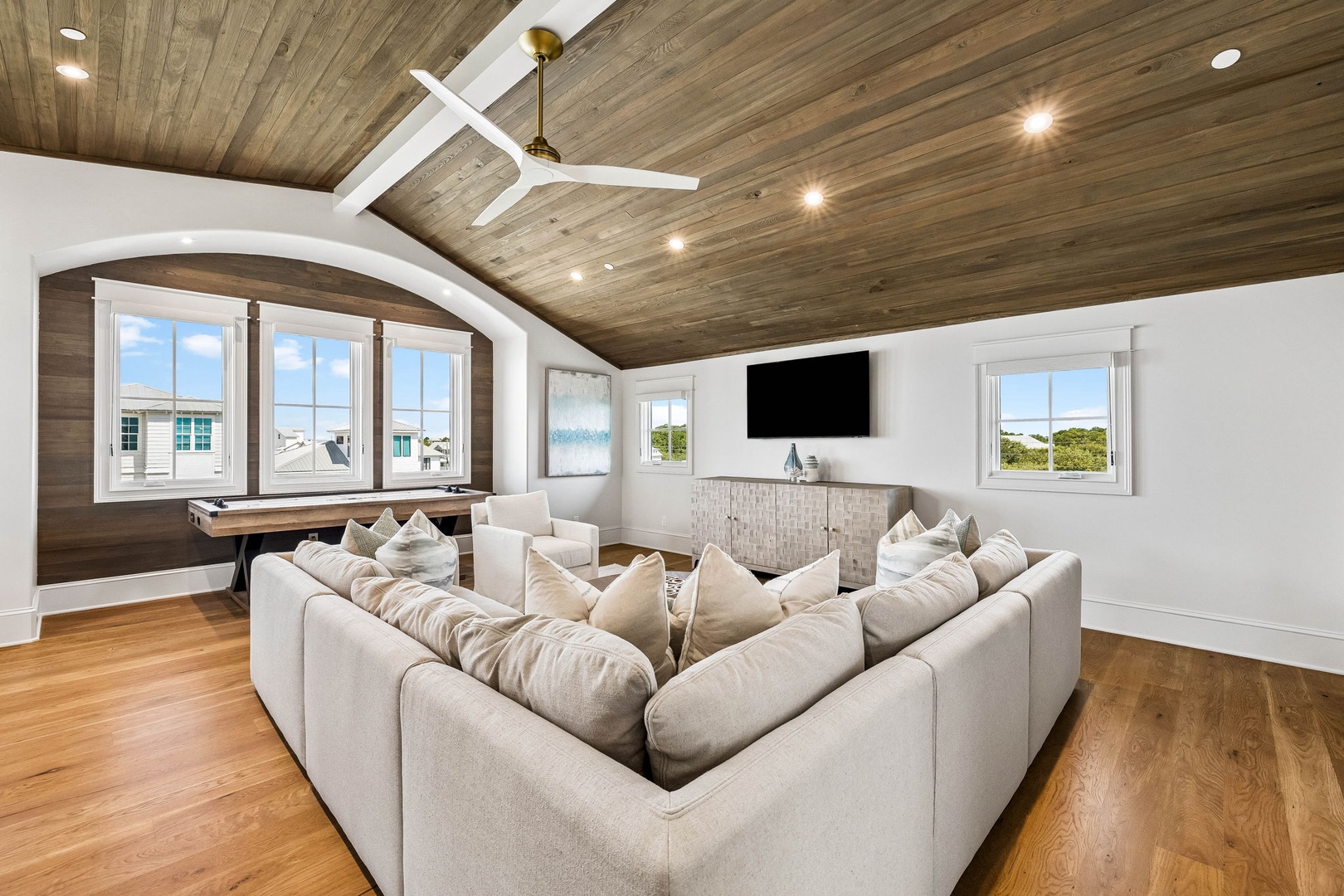 Unwind in this spacious lounge with vaulted wood ceilings, plush sectional seating, and coastal views that invite you to relax in style.
