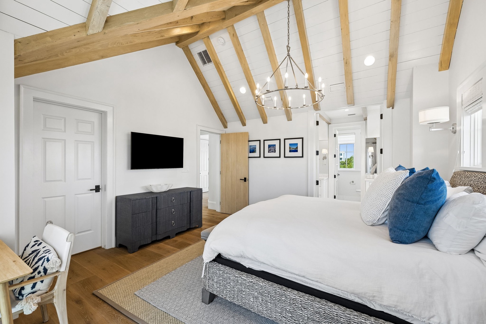 Sink into crisp white linens and let the vaulted ceilings and warm wood beams create your peaceful retreat. Wake up refreshed in this spacious bedroom designed for total relaxation.