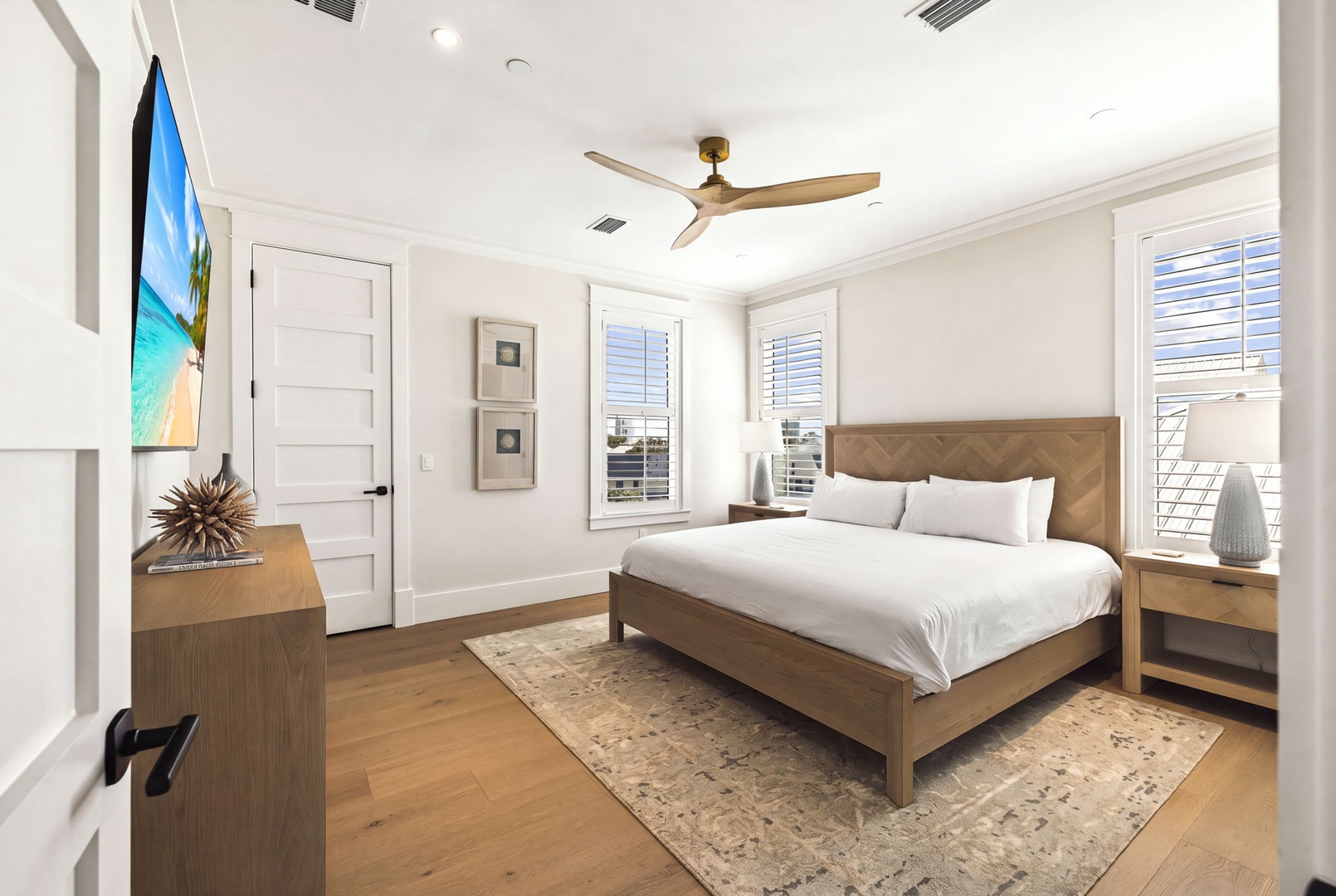 Your peaceful bedroom retreat features a plush bed, ceiling fan for comfort, and plantation shutters that invite natural light while keeping things cool and private.