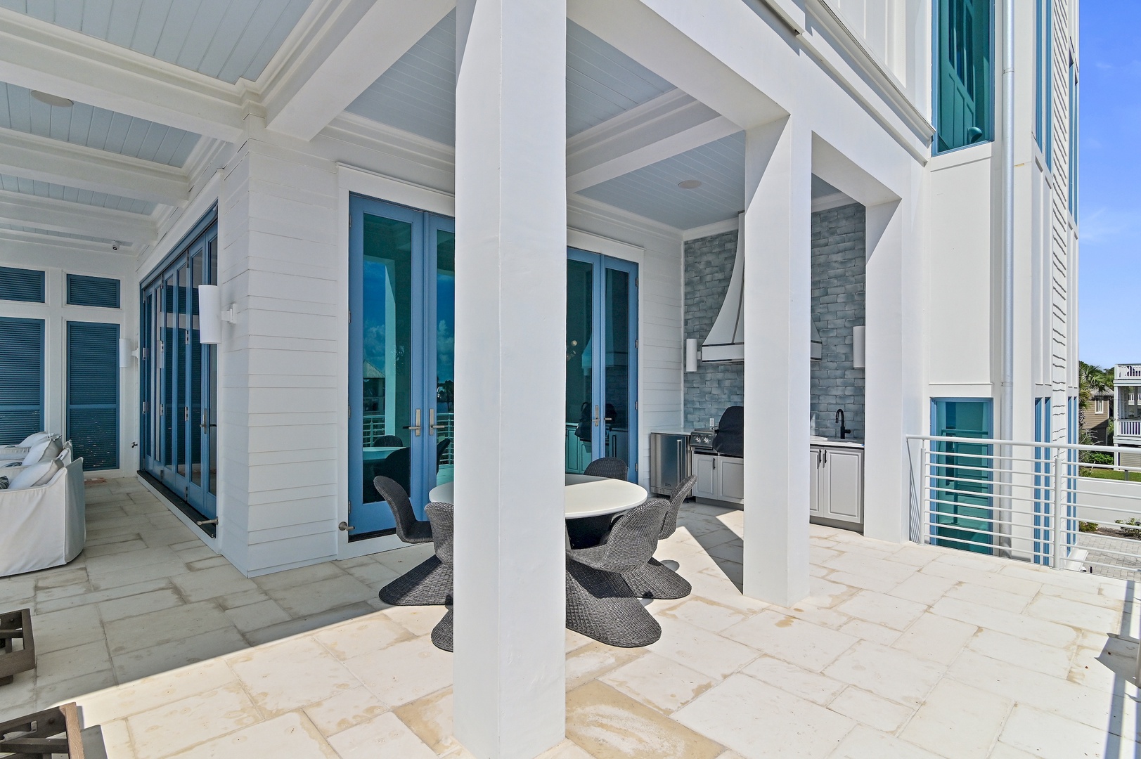 Gather for coastal meals on your covered patio, complete with a built-in grill and sleek seating—your perfect spot for laid-back beachside dining.