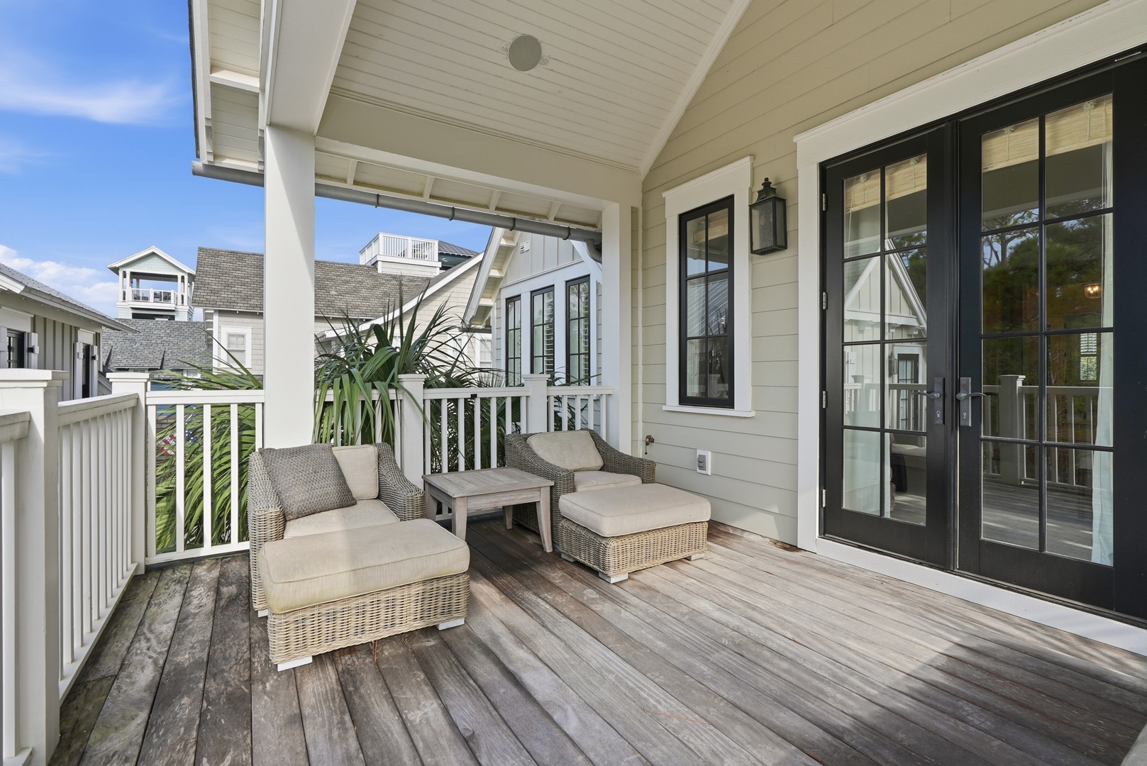 Settle into your private covered deck, where plush wicker seating and coastal greenery create the perfect spot to sip morning coffee or unwind with evening cocktails.