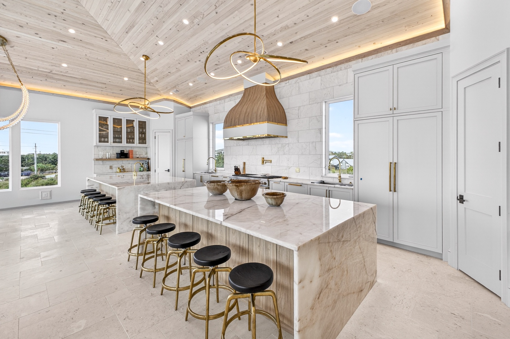 Step into your chef's paradise with gleaming marble counters, brass accents, and a stunning wood-beamed ceiling that creates the perfect backdrop for culinary adventures.