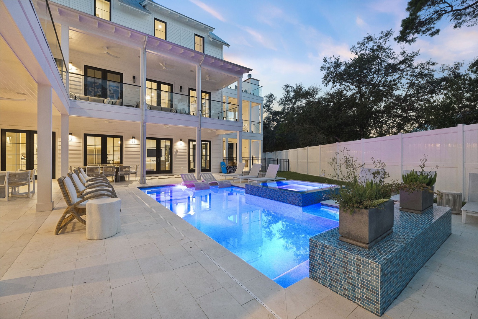 Modern coastal home with private pool, spa, and multiple balconies surrounded by lush trees. A bright, airy retreat perfect for your next vacation.