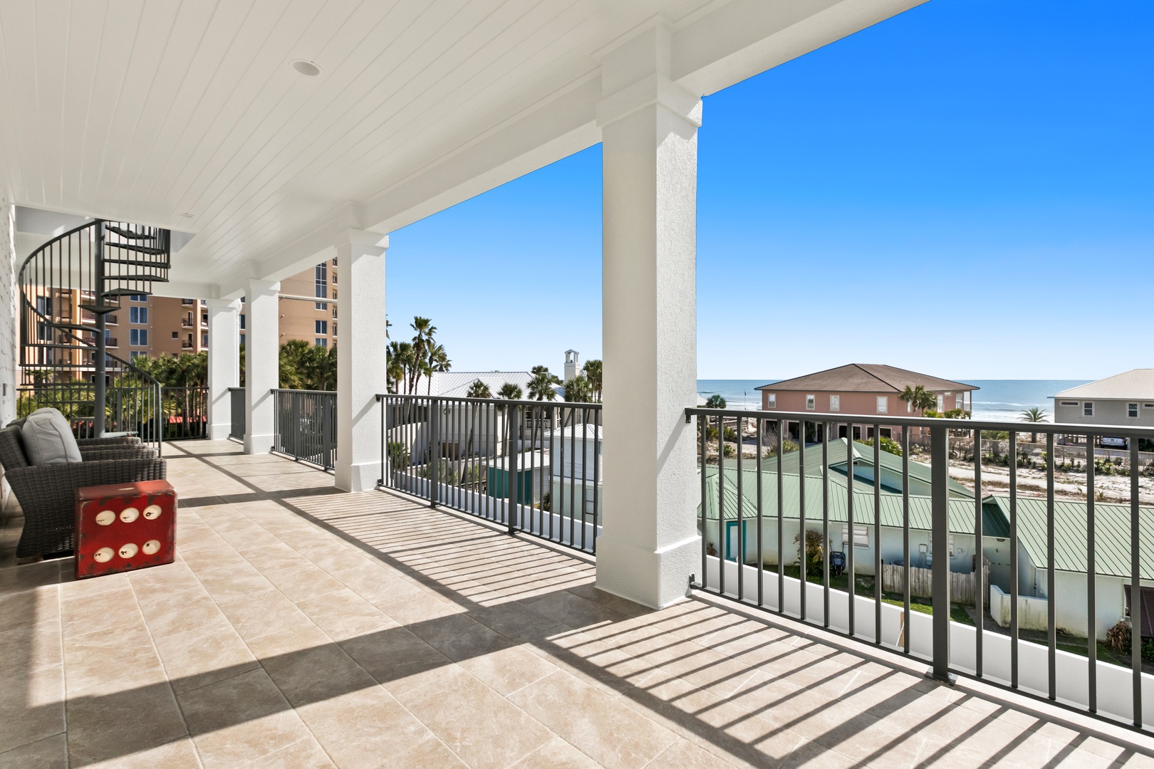 Covered balcony with tile flooring overlooks the waterfront neighborhood, complete with boat docks and palm trees.