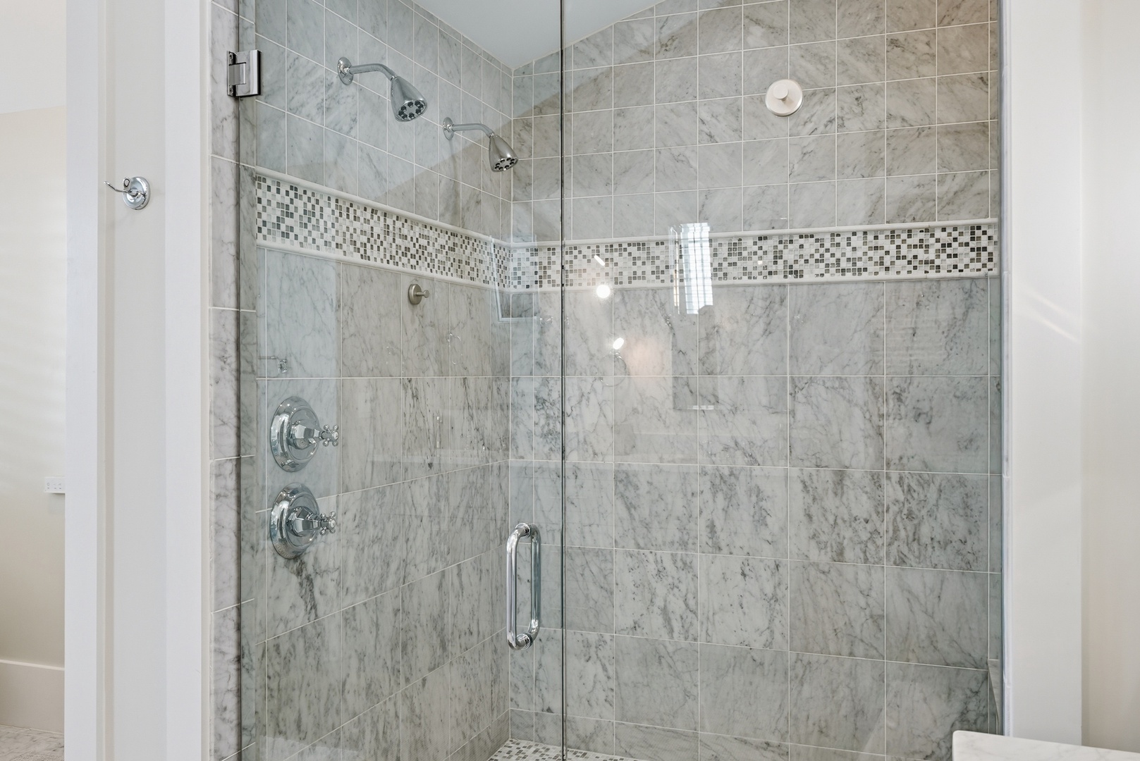 Step into your own private spa retreat with this stunning marble shower. Dual showerheads and elegant tile work create a luxurious space where you can truly unwind.