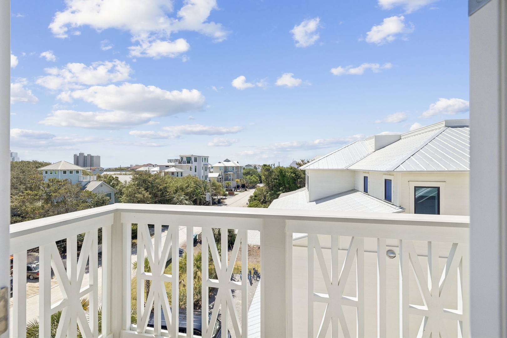 Charming neighborhood views with coastal architecture and lush landscaping visible from your private balcony retreat.
