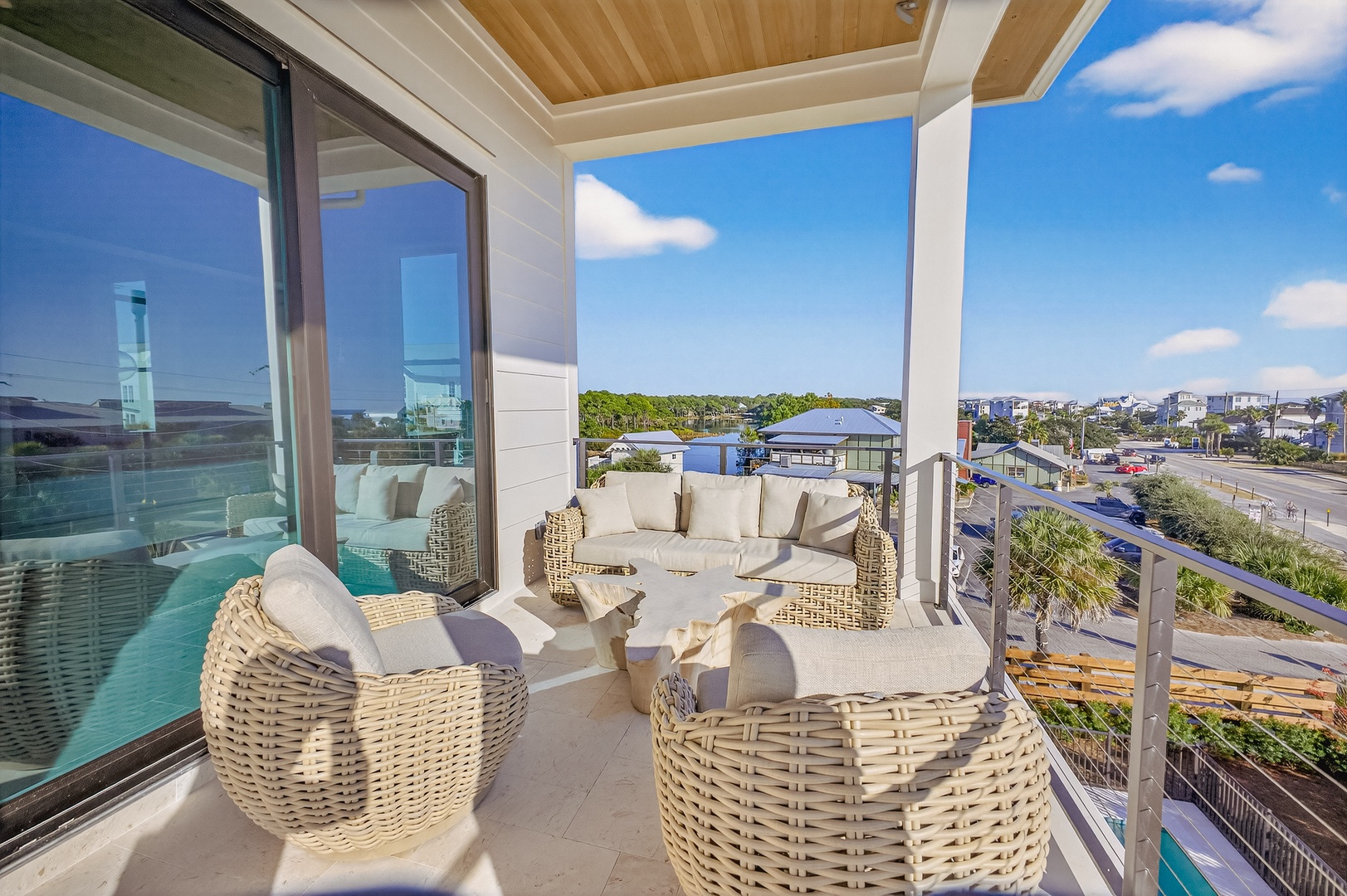 Relax in style on your private covered terrace with plush wicker seating overlooking a stunning coastal neighborhood view.