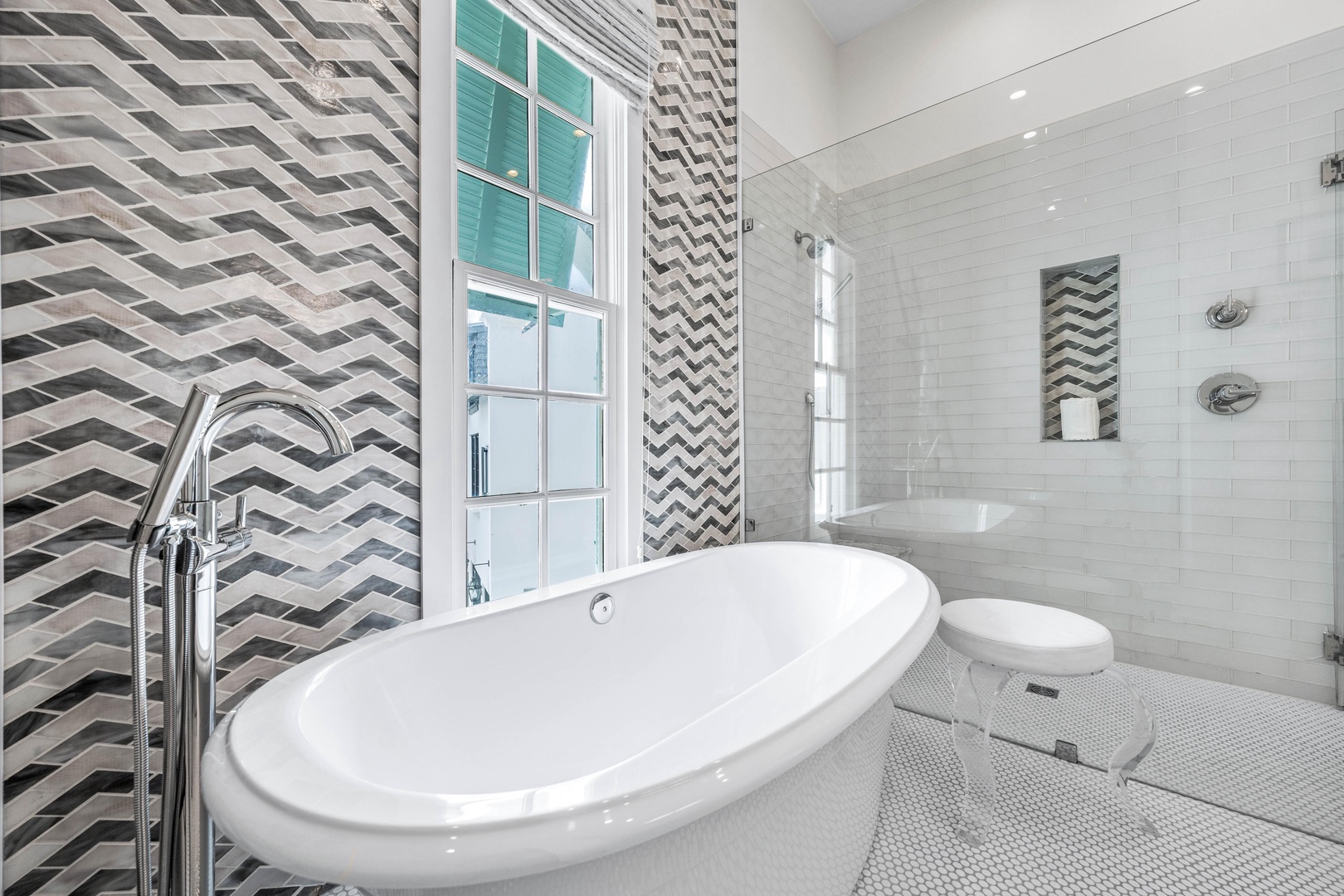 Slip into this elegant freestanding tub where chevron tiles and natural light create your perfect retreat for unwinding.