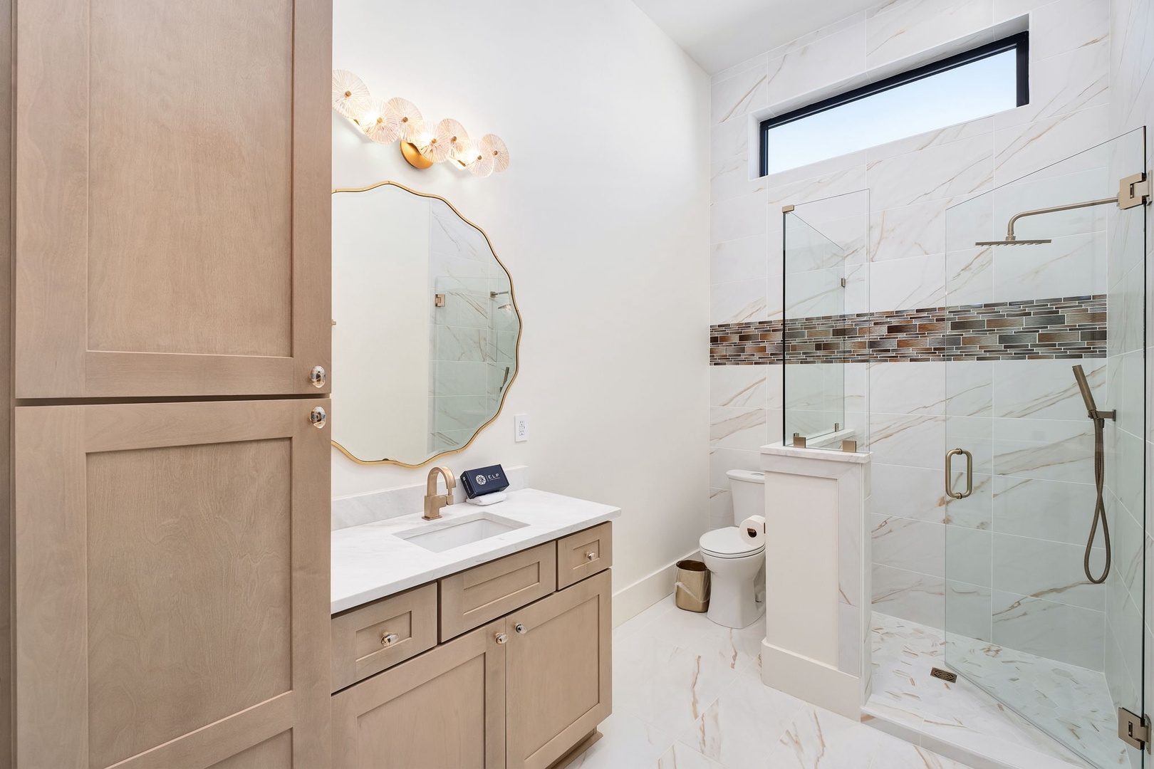 Unwind in your elegant marble bathroom featuring a walk-in shower, stylish vanity, and designer lighting for luxurious relaxation.