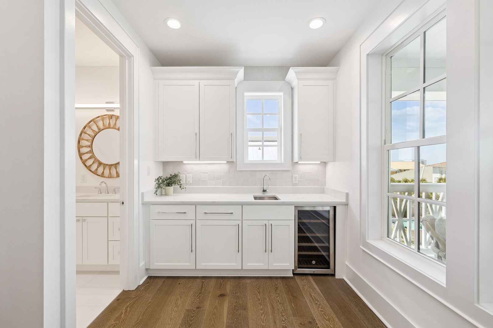 Your bright kitchen features pristine white cabinets, quartz countertops, and a built-in wine fridge for evening relaxation.