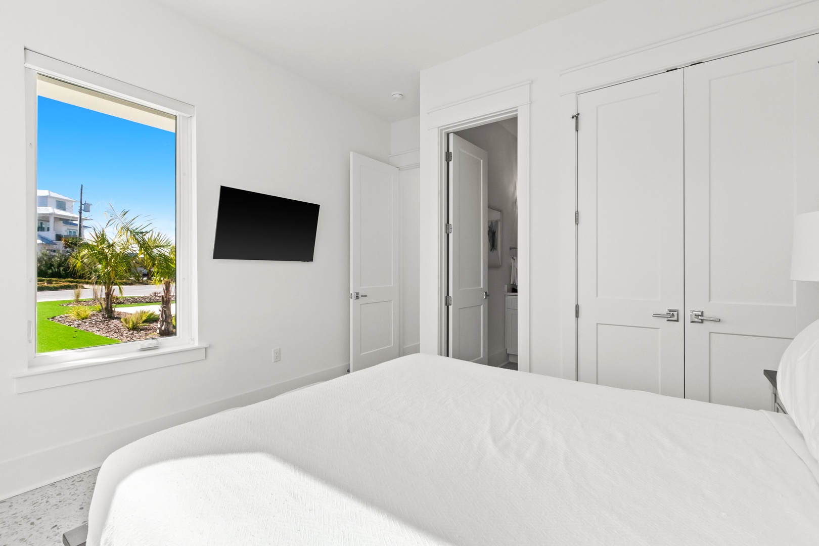 Sink into your inviting bed, where crisp linens and peaceful views of greenery through the window help you unwind. The bright, airy space feels fresh and restful—a perfect retreat after exploring.