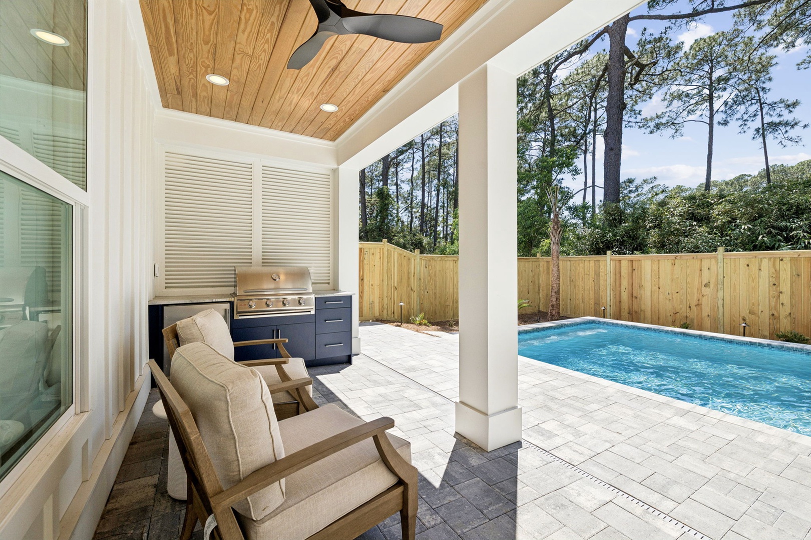 Your private outdoor retreat awaits with a sparkling pool, covered lounge area with BBQ grill, and serene backyard views—perfect for relaxing poolside or hosting unforgettable gatherings.