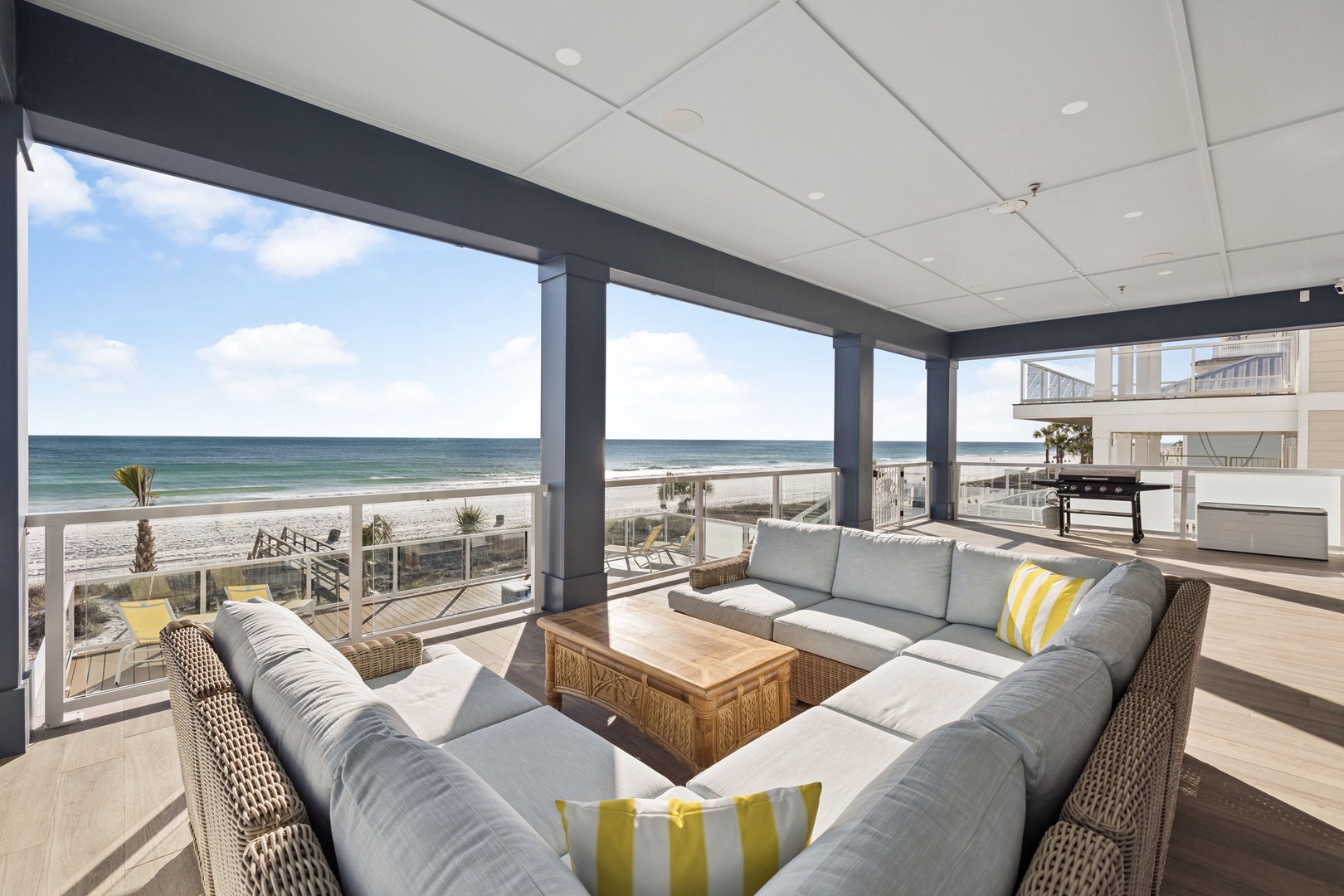 Relax on plush seating while soaking in breathtaking ocean views through floor-to-ceiling windows in your spacious beachfront living area.