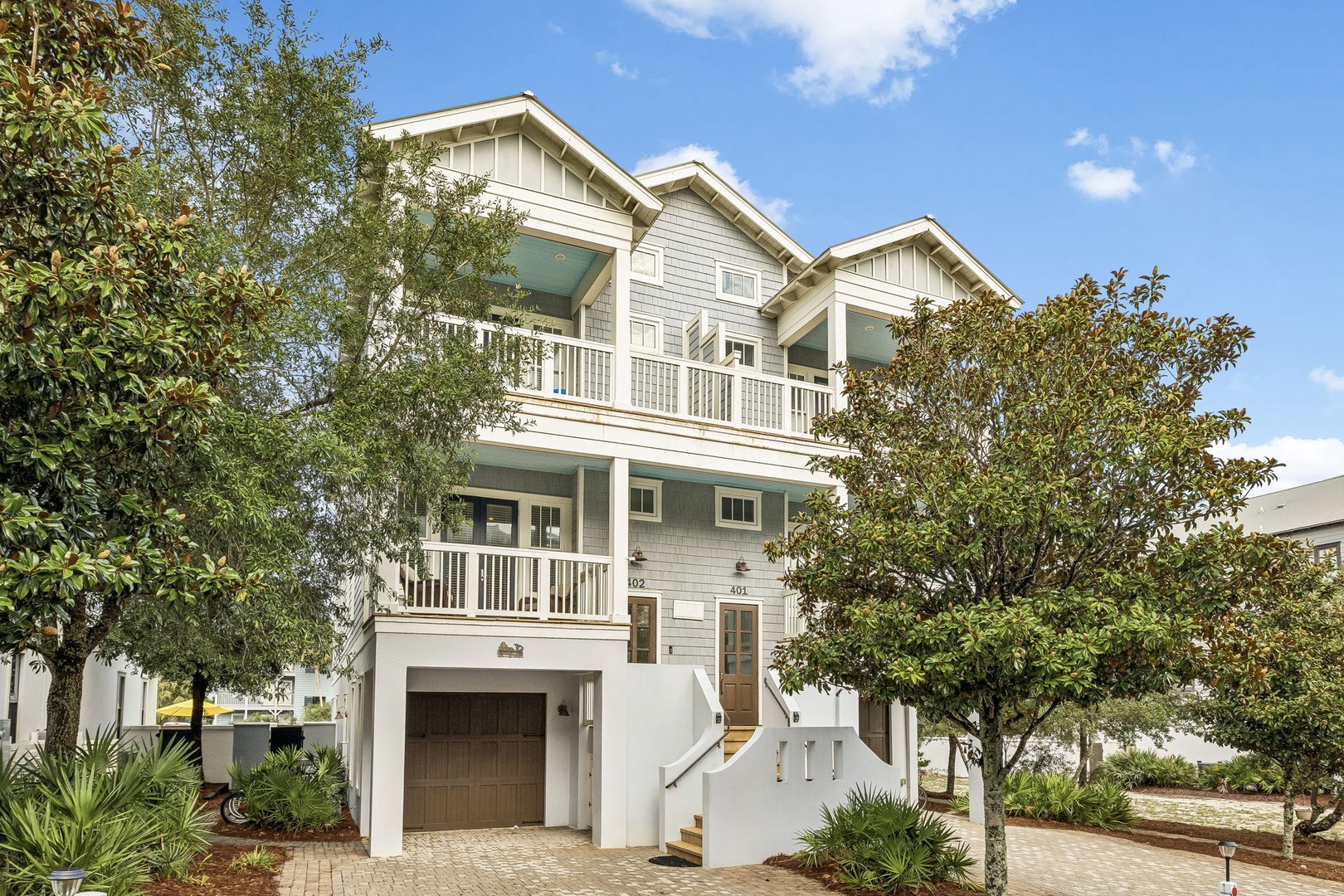This charming coastal-style building offers a welcoming arrival experience, framed by lush greenery and sunny skies. The multi-level architecture provides attractive curb appeal in a beautifully landscaped setting.