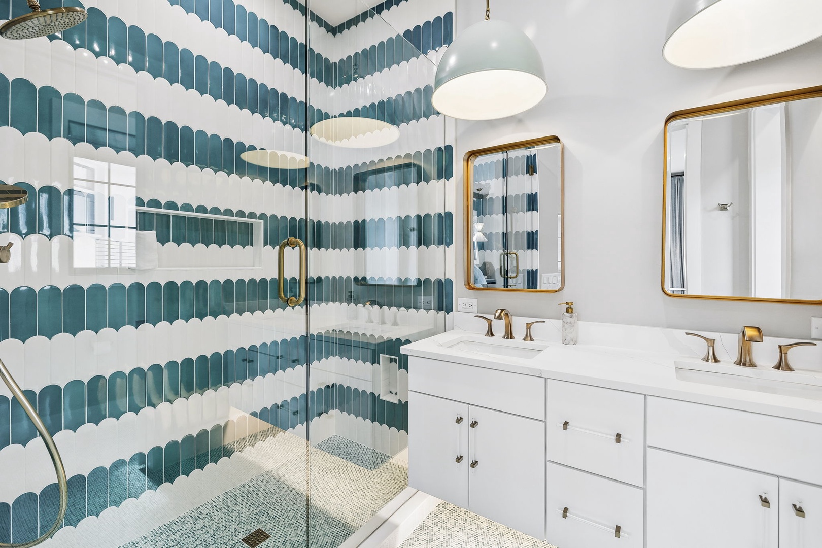 Step into your stunning bathroom, where scalloped teal-and-white tilework creates a soothing coastal vibe. Dual vanities, gold fixtures, and a spacious walk-in shower make refreshing easy after a day exploring the area.