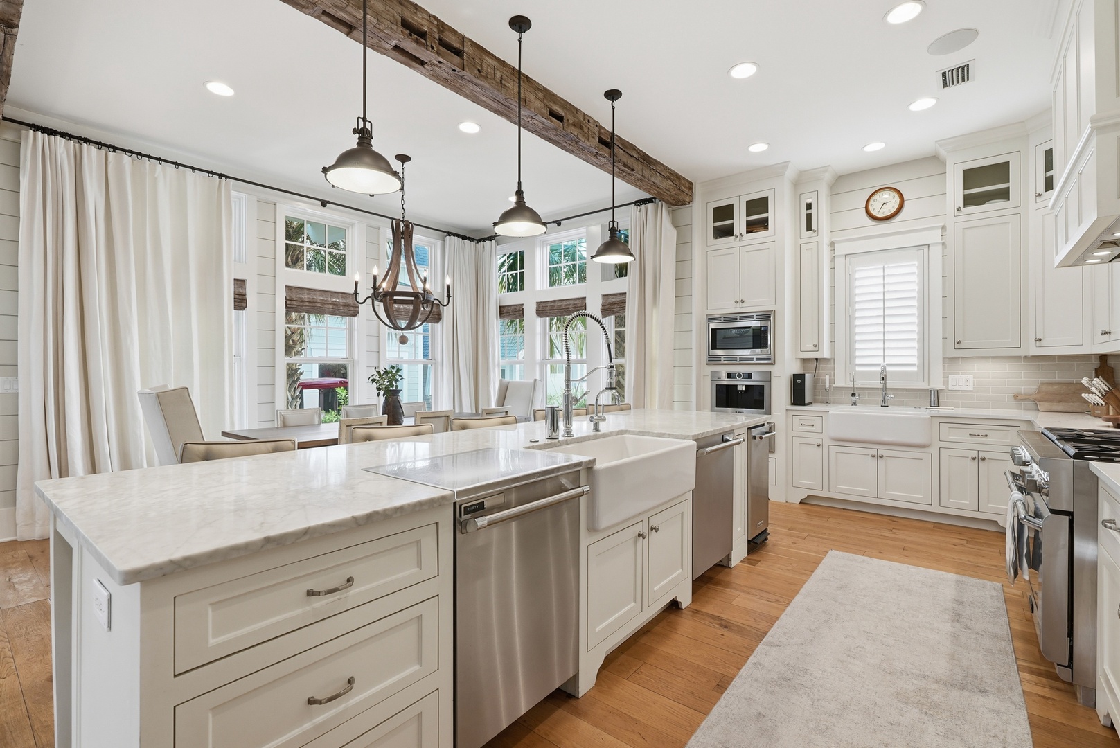 Picture yourself cooking meals together in this bright, open kitchen with rustic beams, marble countertops, and farmhouse charm—your perfect home-away-from-home gathering spot.