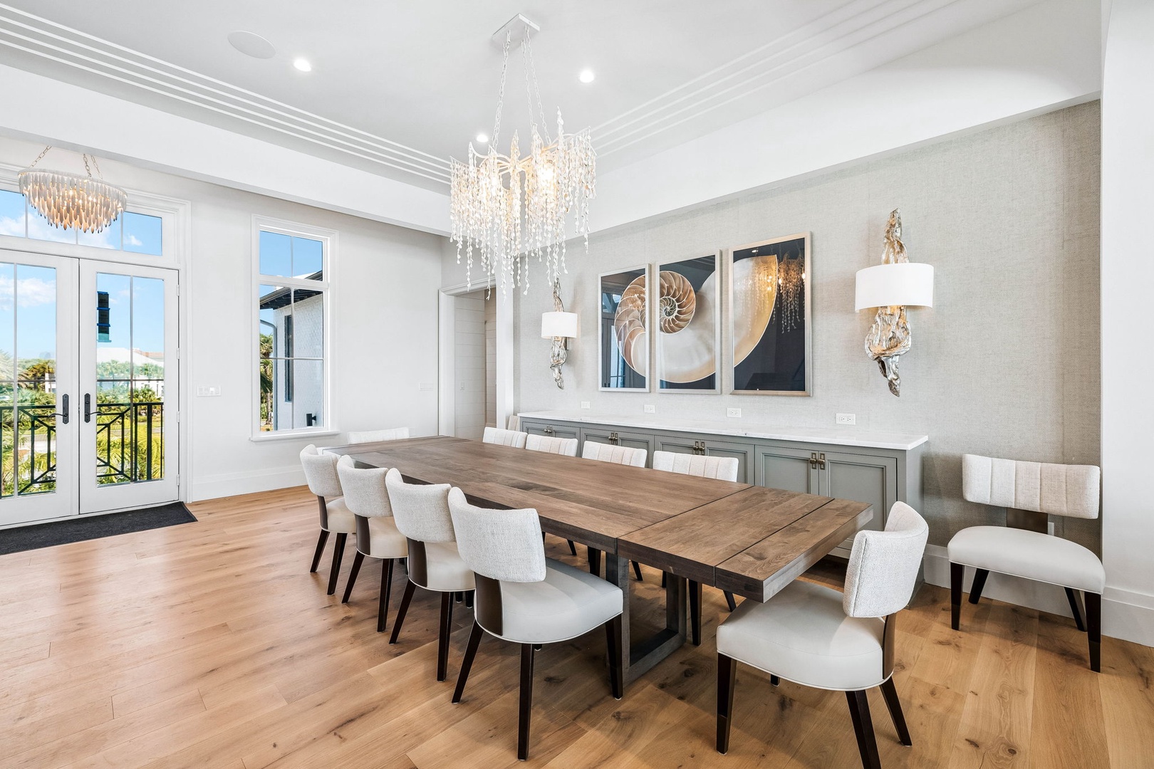 Gather around this stunning dining table for memorable meals together. The elegant chandelier, spacious design, and abundant natural light create the perfect setting for your vacation celebrations.