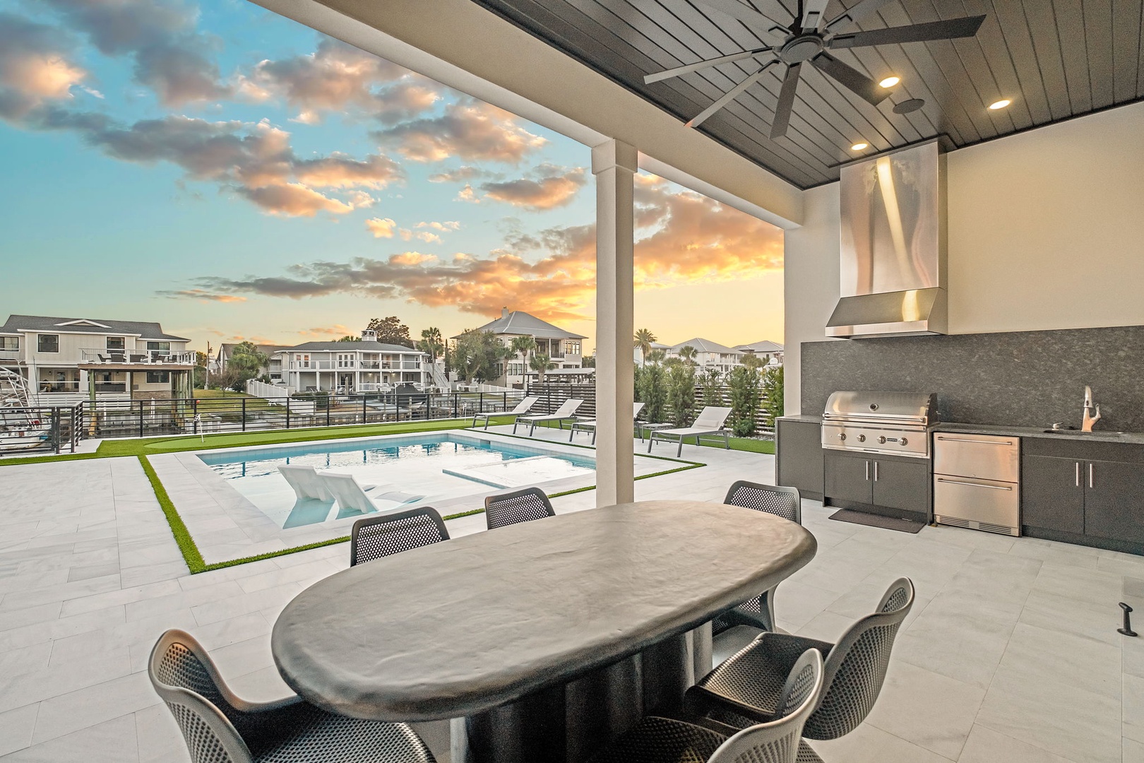 Your covered outdoor dining area opens to a stunning pool with modern BBQ kitchen, perfect for sunset gatherings.
