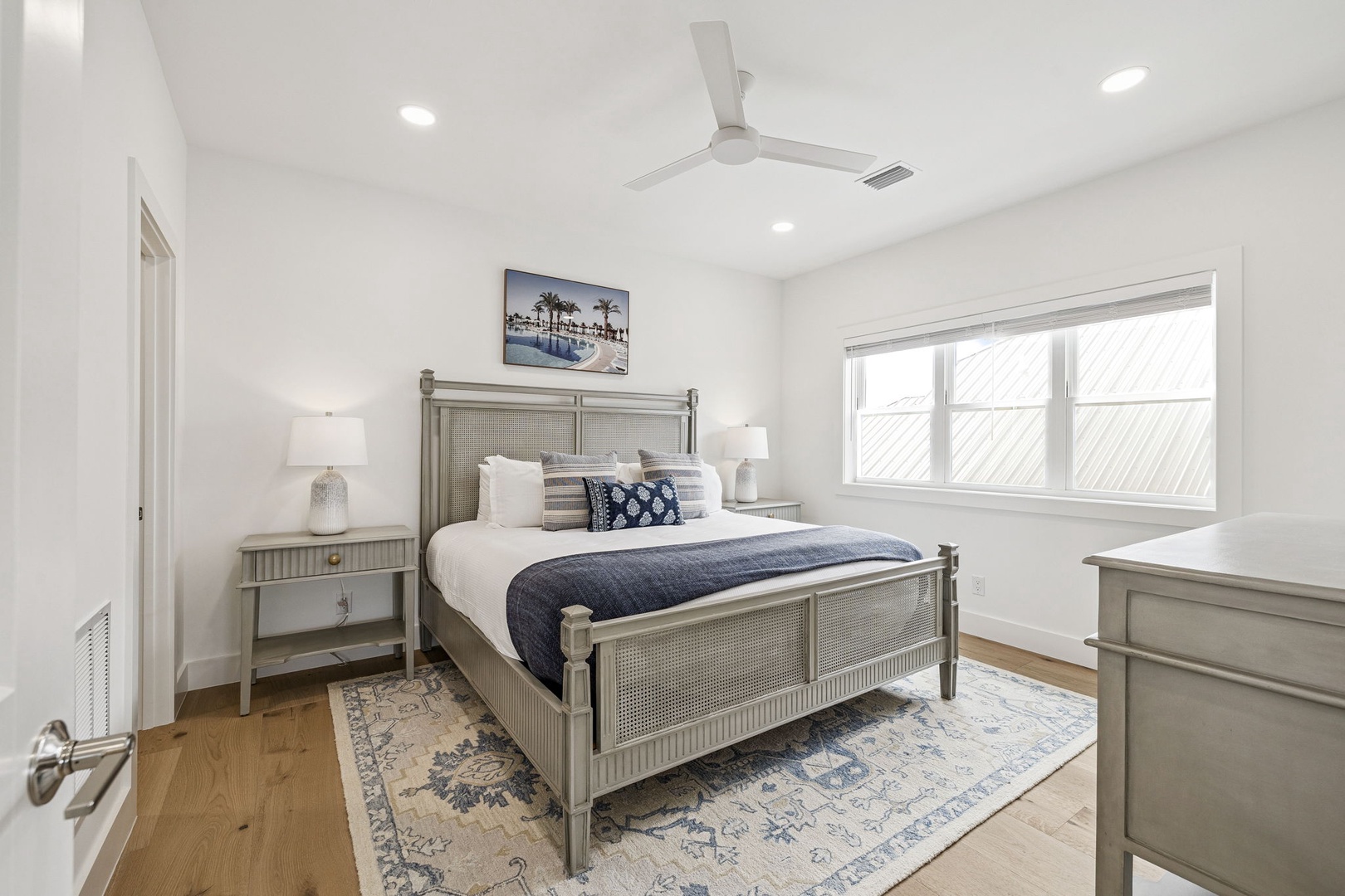 Sink into crisp white linens and coastal-inspired décor in your peaceful bedroom retreat, complete with modern comfort and serene ambiance.