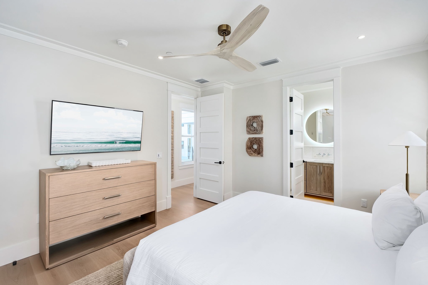 Unwind in your bright, coastal-inspired bedroom with crisp white linens and a ceiling fan to keep you cool. The warm wood finishes and serene decor create the perfect retreat after a day of adventure.