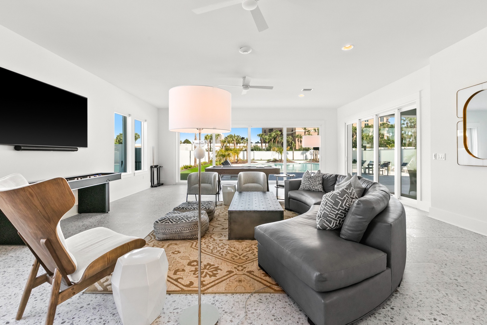 Settle into your bright, modern living space where palm trees sway just beyond the wall of glass doors. With plush seating, a stylish open layout, and seamless indoor-outdoor flow, it's the perfect backdrop for your getaway.