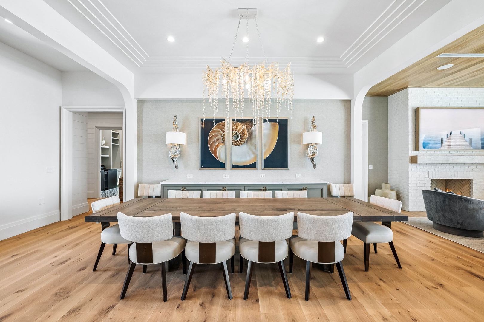 Gather around this stunning dining table, where coastal elegance meets sophisticated design. A sparkling chandelier sets the mood for memorable meals with family and friends.