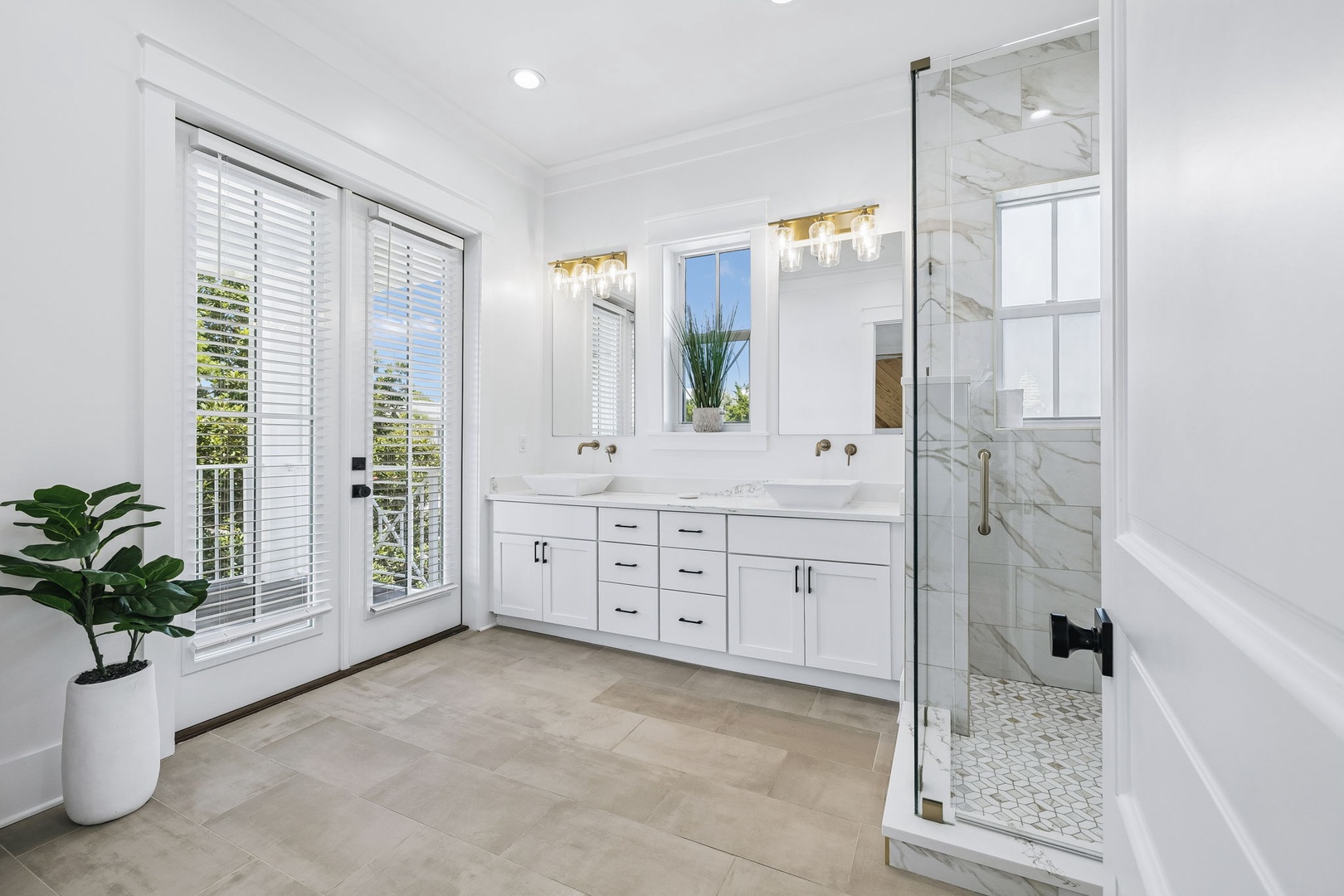 Step into your serene sanctuary—a spa-like bathroom with sleek marble details, a walk-in shower, and natural light streaming through elegant shutters.