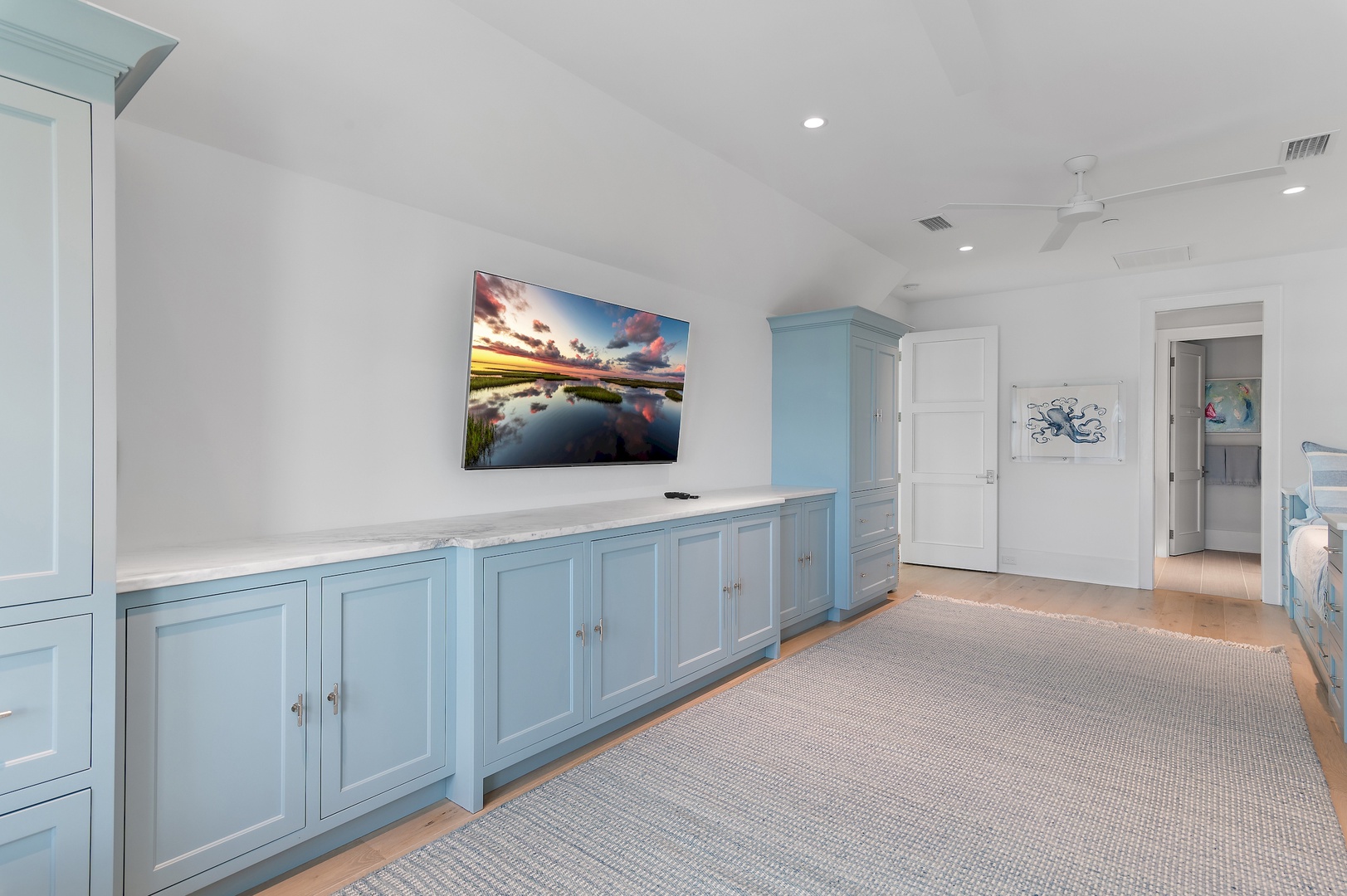 Unwind in your spacious bedroom retreat with custom coastal cabinetry and soft carpeting underfoot. The soothing blue storage keeps your belongings organized while nautical touches create a peaceful, beachside escape.