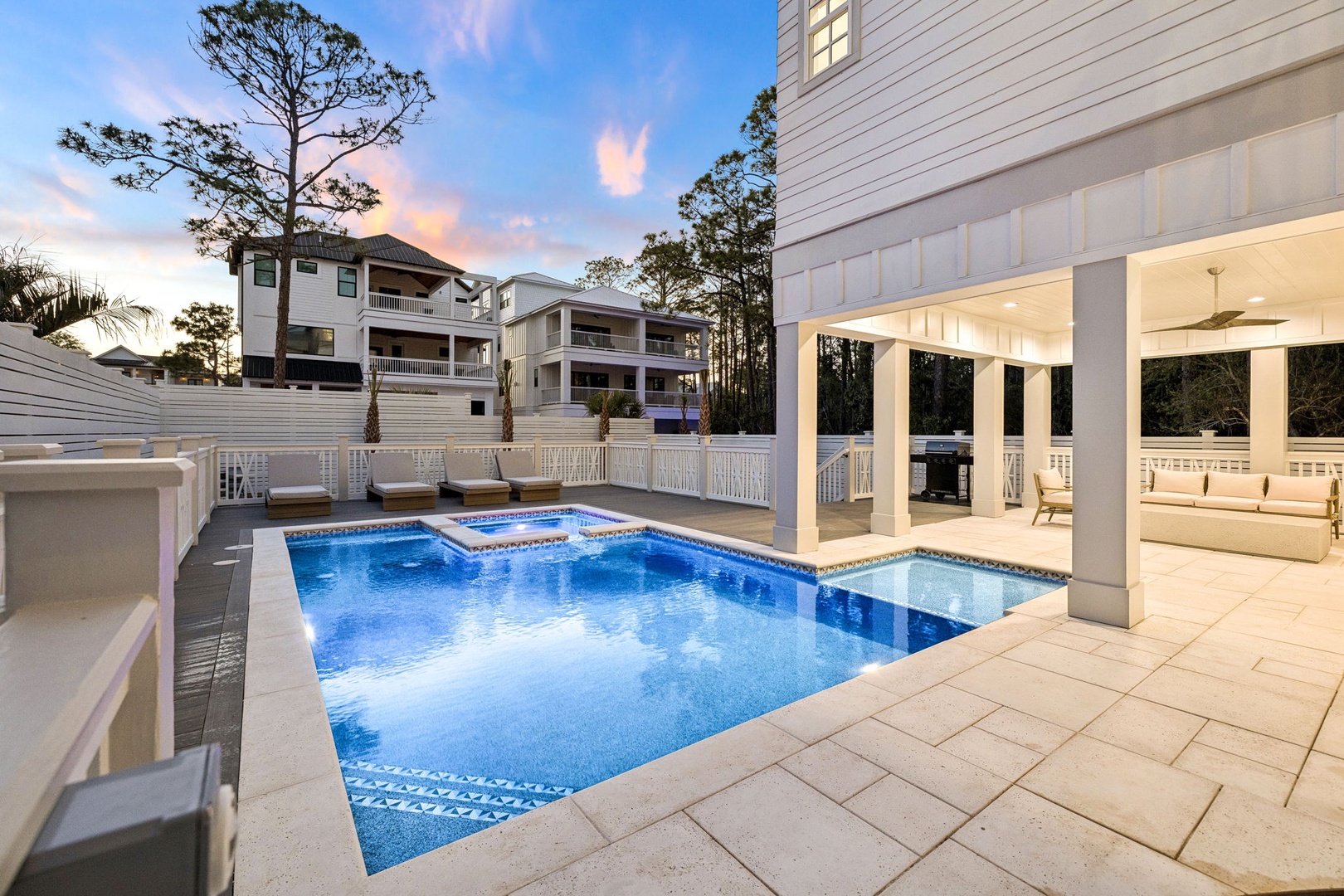 Elegant poolside retreat with covered pavilion and sparkling blue waters at dusk.