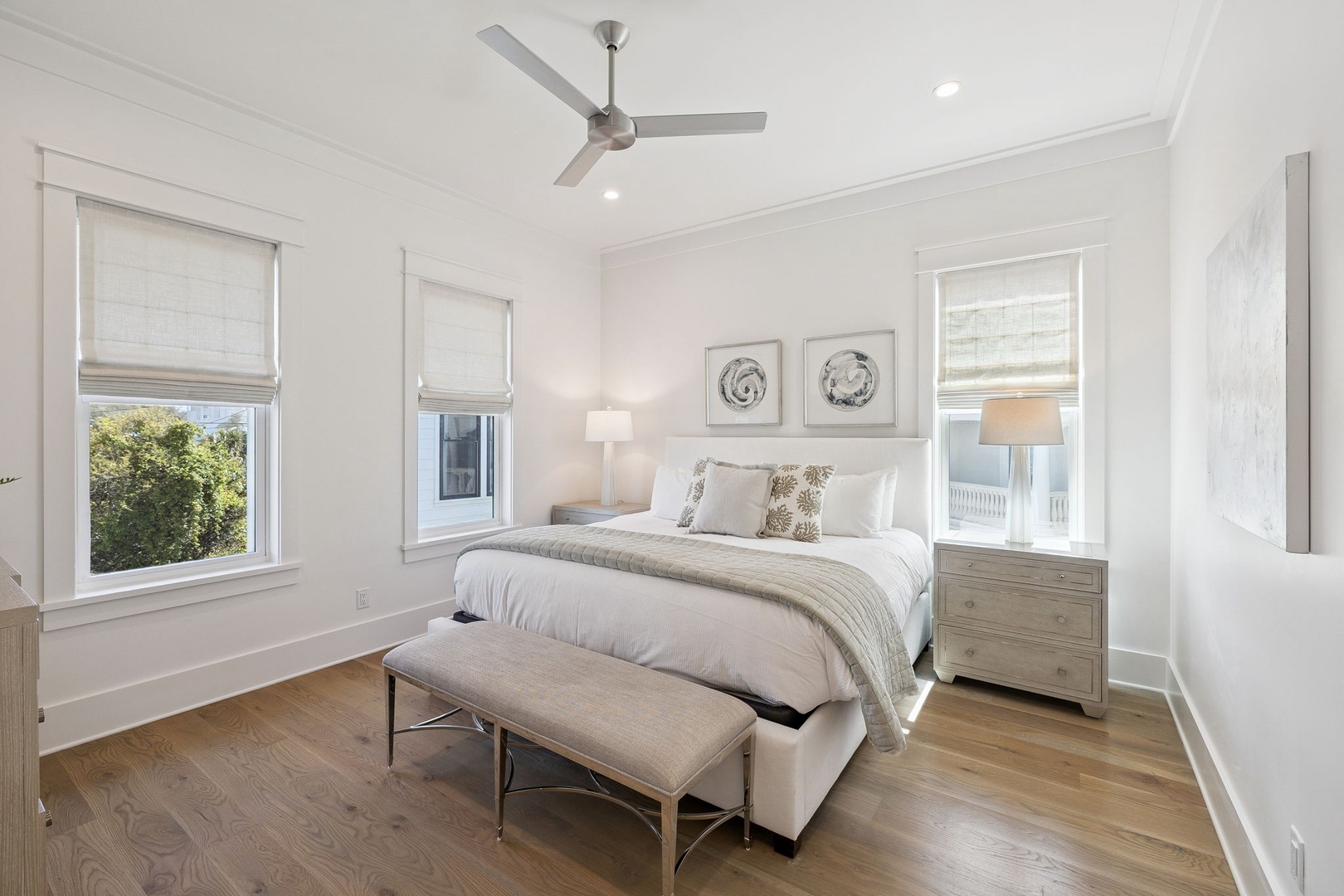 Slip into luxurious comfort in your serene bedroom, where natural light filters through elegant blinds and a gentle ceiling fan ensures perfect sleep.