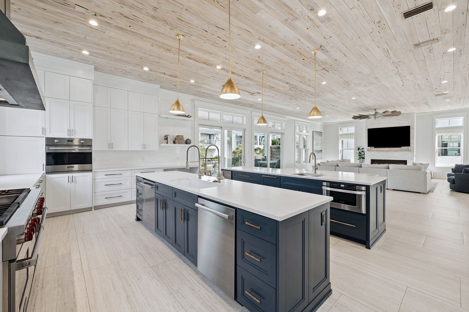 Your gourmet kitchen awaits with dual islands, quartz countertops, and gold pendant lights beneath stunning wood-plank ceilings.