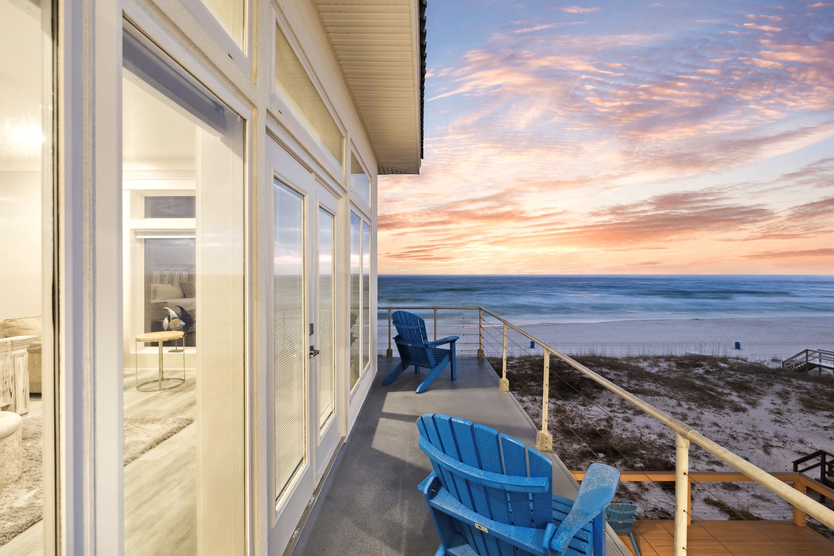 Spectacular beachfront property offers panoramic ocean views and pristine sandy shoreline access beneath dramatic sunset skies.