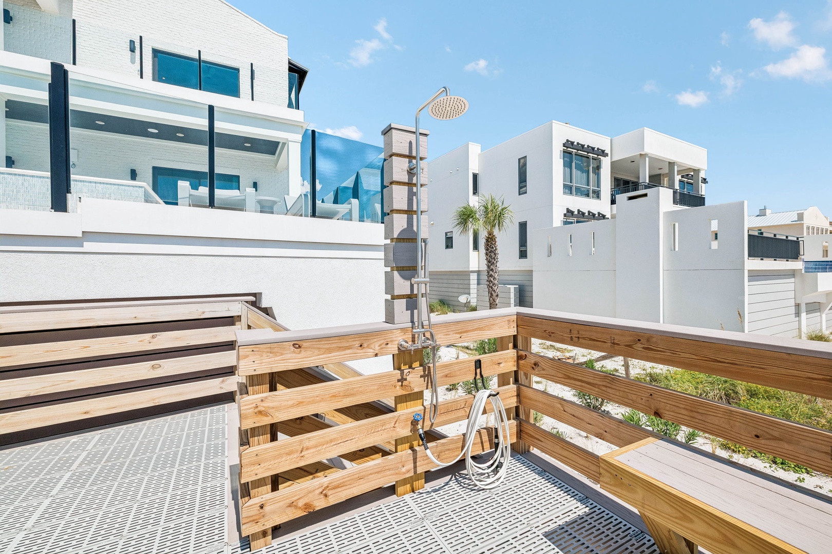Step out onto your private outdoor terrace and breathe in the sunshine. Modern white architecture surrounds you, while a sleek outdoor shower invites you to rinse off under open skies.
