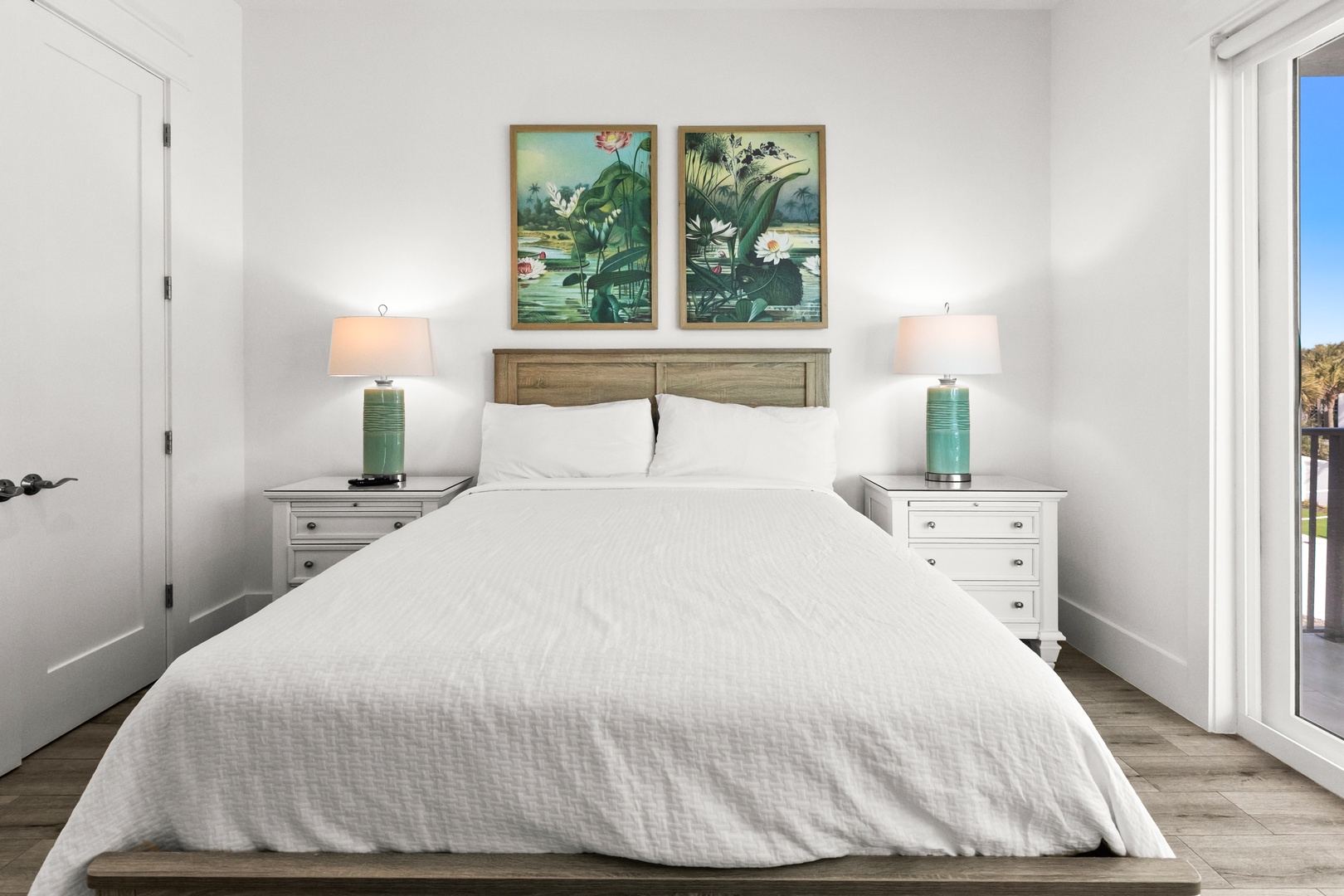 Sink into crisp linens and wake refreshed in this serene bedroom, where soft lighting and coastal-inspired art set a calming tone for your stay.
