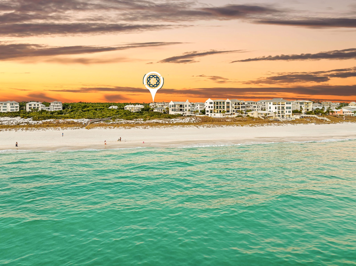 Pristine beachfront location with crystal-clear turquoise waters and white sand beach stretching along the coastline at sunset.